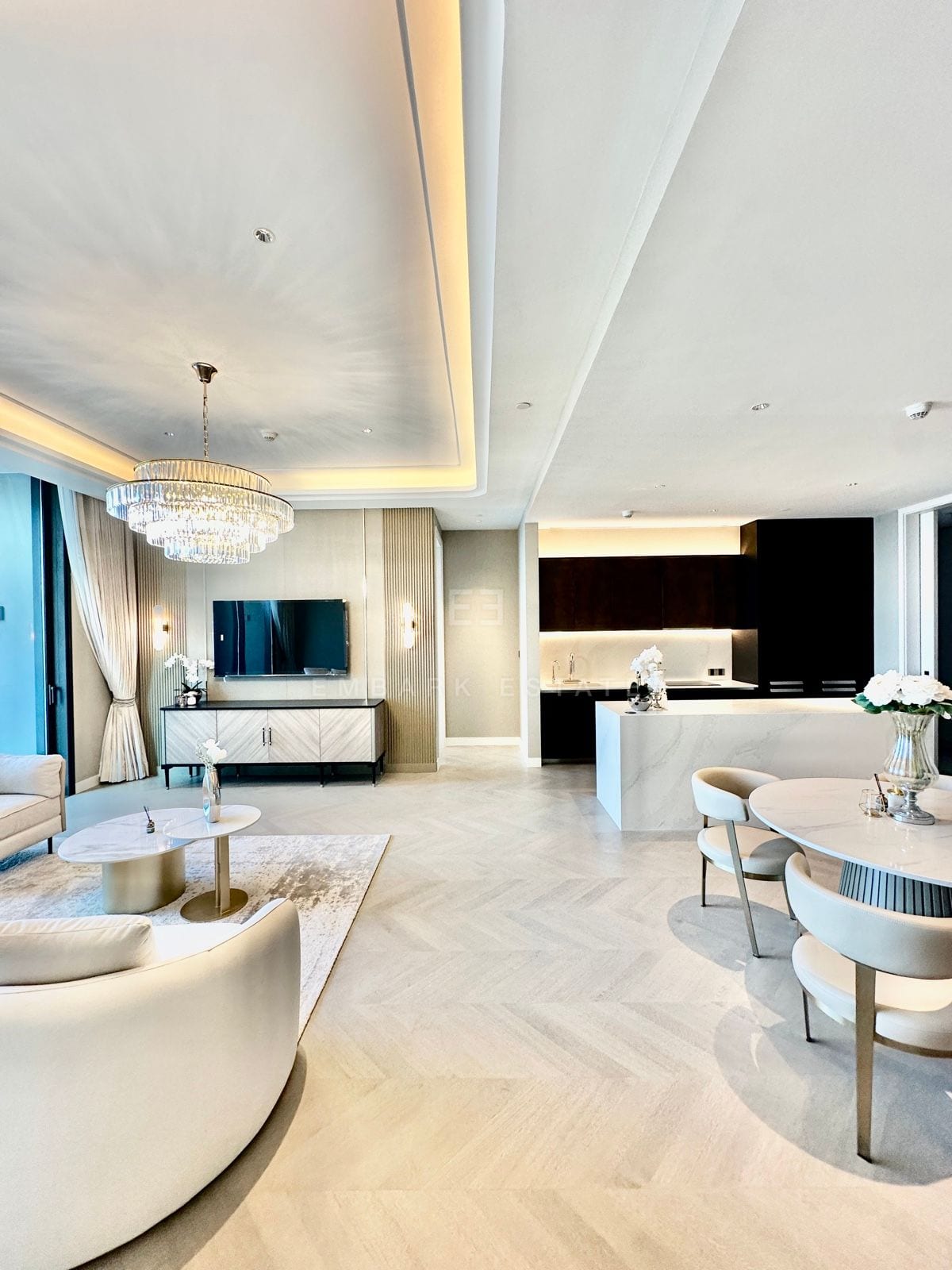 The living and dining area of a two-bedroom residence at ONE89 Wireless, One Bangkok, with the marble kitchen island beyond