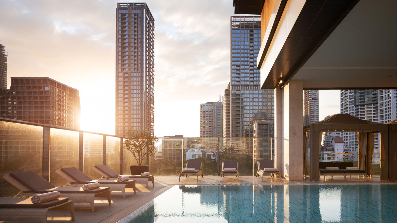 Oriental Residence Bangkok: rooftop swimming pool with skyline at sunset