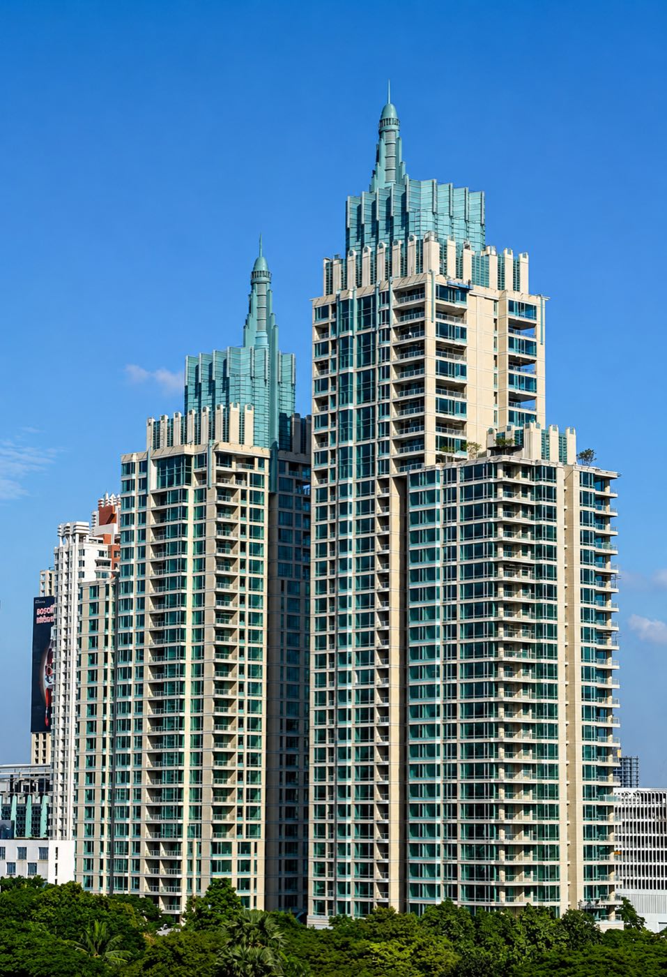 The Park Chidlom twin residential towers with their pale-green spires rising above the trees of Soi Chidlom in central Bangkok