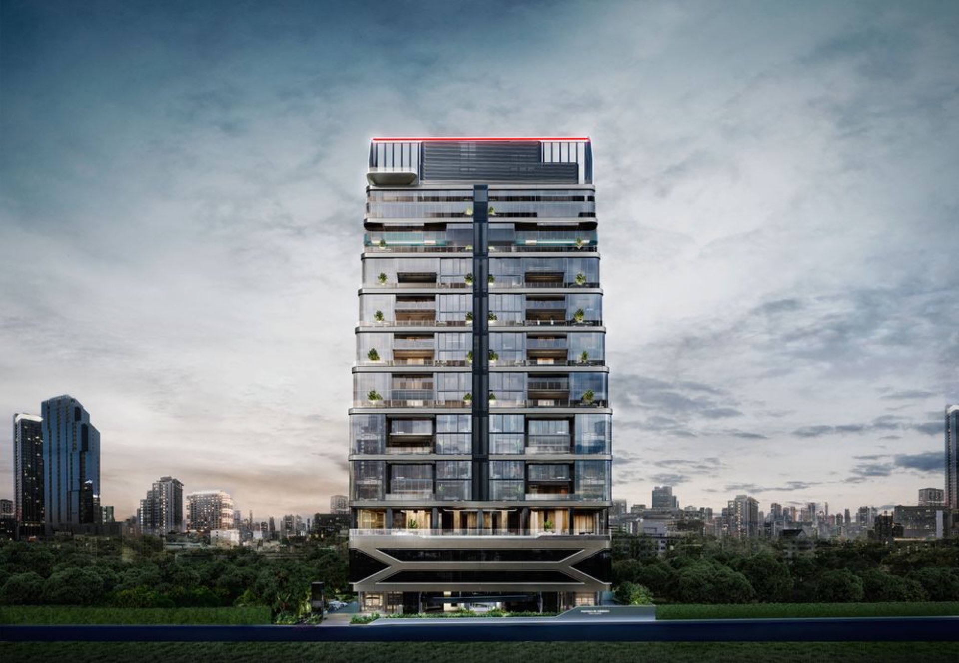 Porsche Design Tower Bangkok: Full front elevation of the Porsche Design Tower Bangkok at dusk, the glass-and-steel residential tower rising above the city skyline with its red-lit crown