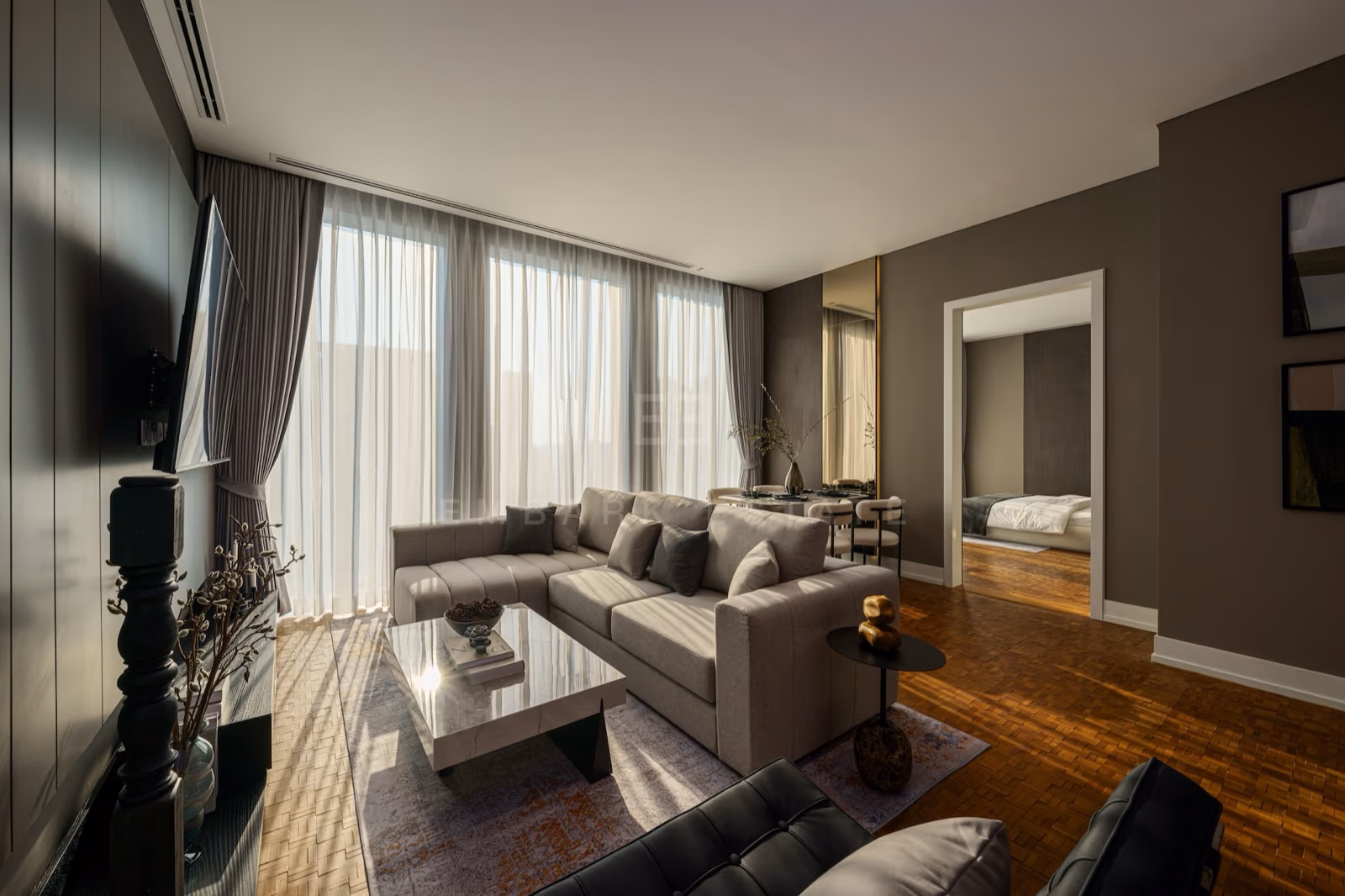 The living room of a two-bedroom residence at The Ritz-Carlton Residences Bangkok, with a corner sofa, sheer curtains across full-height glass and the city beyond
