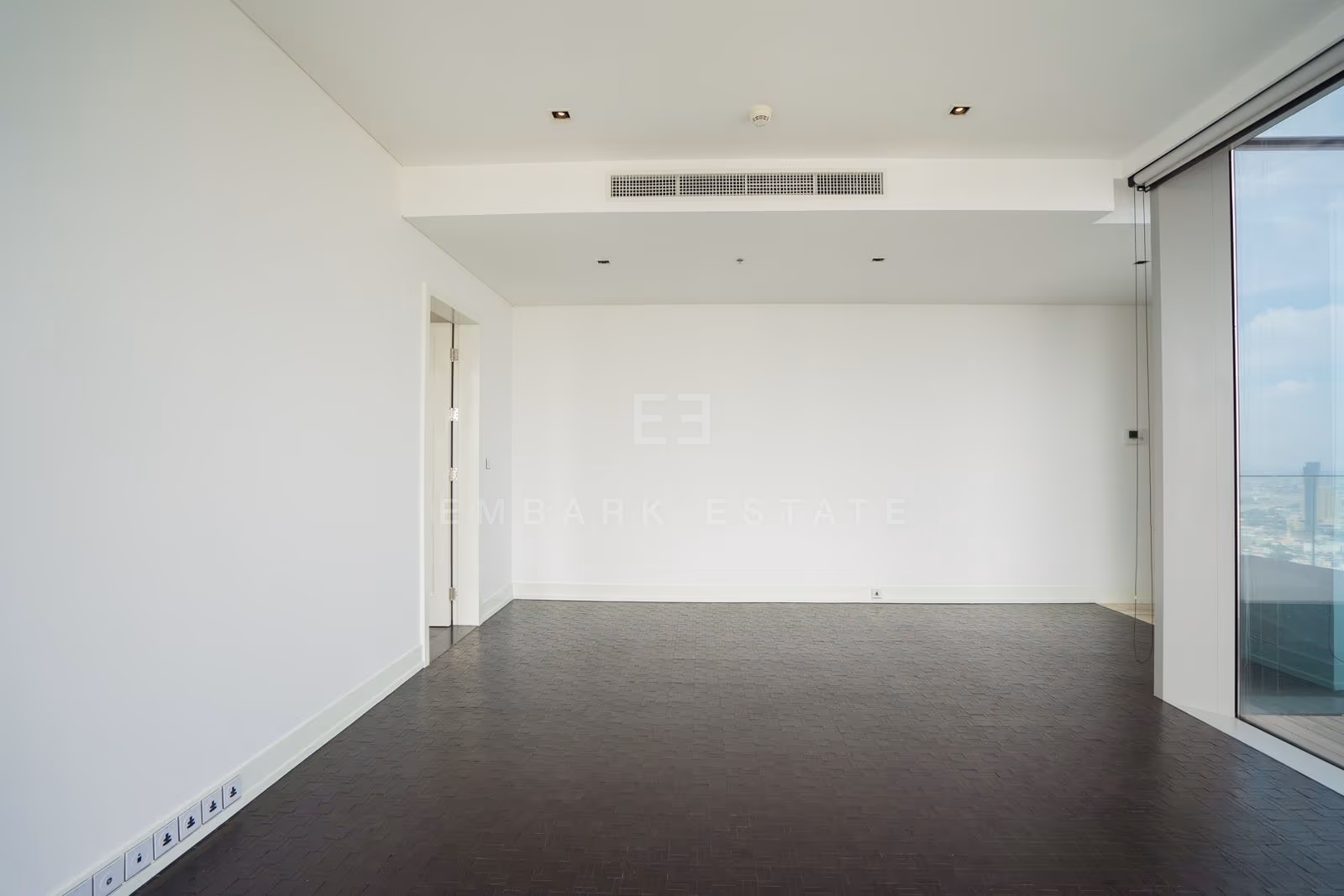A reception room on the 49th floor at The Ritz-Carlton Residences Bangkok, dark parquet running to glazing on one side