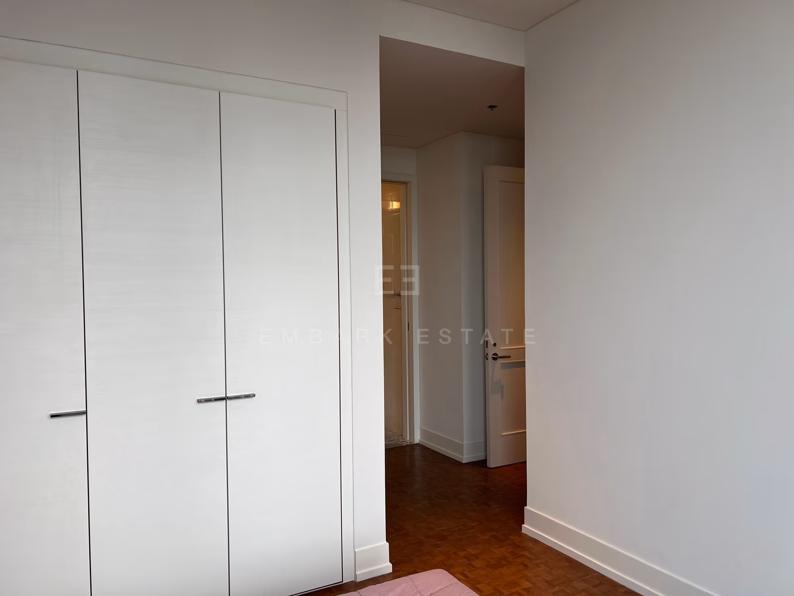The bedroom corridor on the 31st floor at The Ritz-Carlton Residences Bangkok, fitted wardrobe doors along one side and parquet running to the hall