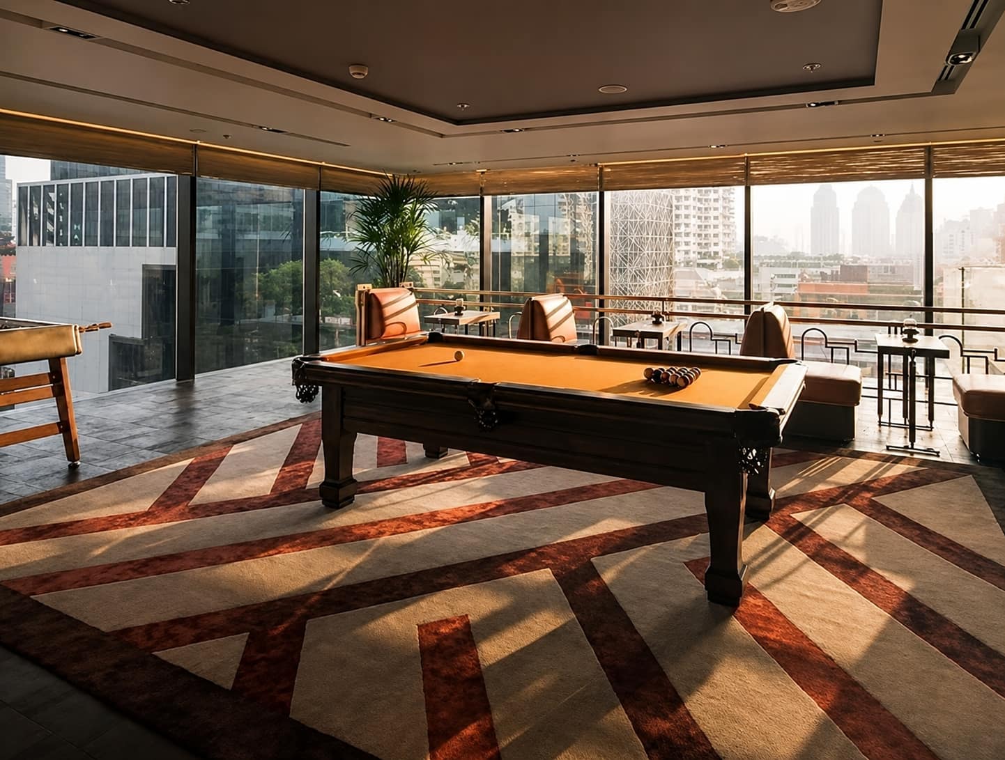 The Ritz-Carlton Residences Bangkok: the residents' games room with a billiards table and foosball beside floor-to-ceiling windows over the city