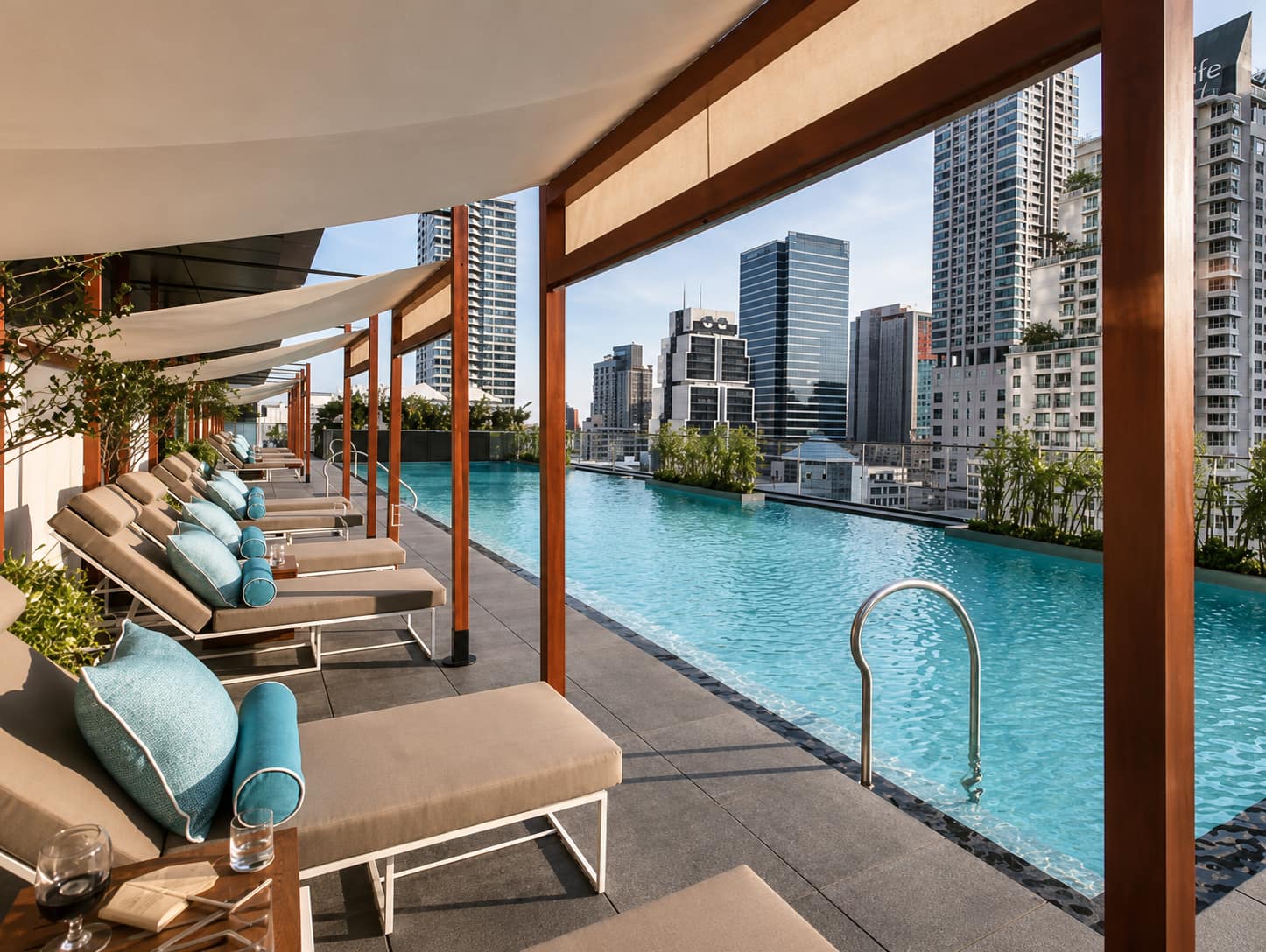 The Ritz-Carlton Residences Bangkok: sun loungers under cabanas beside the infinity-edge pool overlooking the city