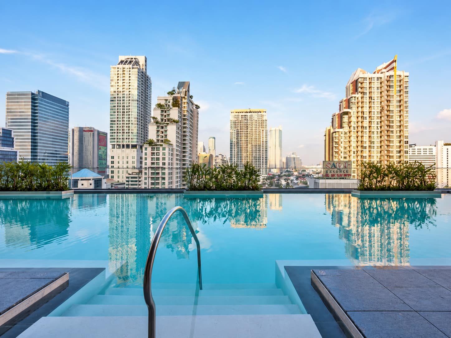 The Ritz-Carlton Residences Bangkok: the rooftop swimming pool with an infinity edge over the central Bangkok skyline at dusk