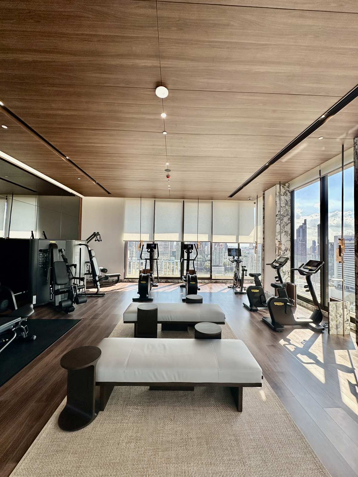 Cardio equipment along the windows of the fitness room at ROMM Convent, Bangkok.