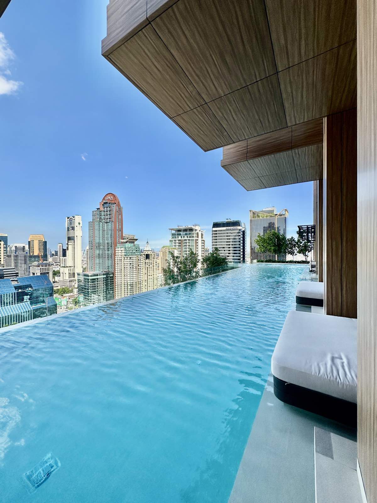 Rooftop infinity pool with a sun lounger at ROMM Convent, Bangkok.