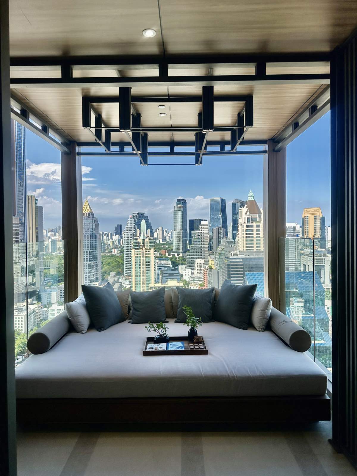 Sheltered daybed nook in a timber-framed sky deck at ROMM Convent, Bangkok.