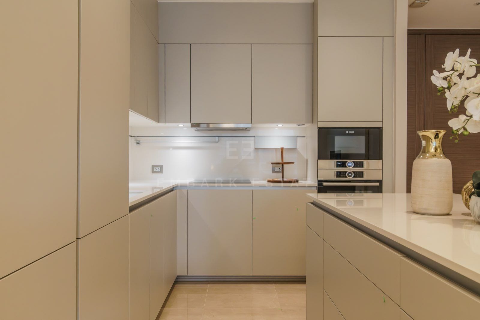 The kitchen of the two-bedroom residence at the Residences at Sindhorn Kempinski, Bangkok, with beige cabinetry and built-in Bosch appliances