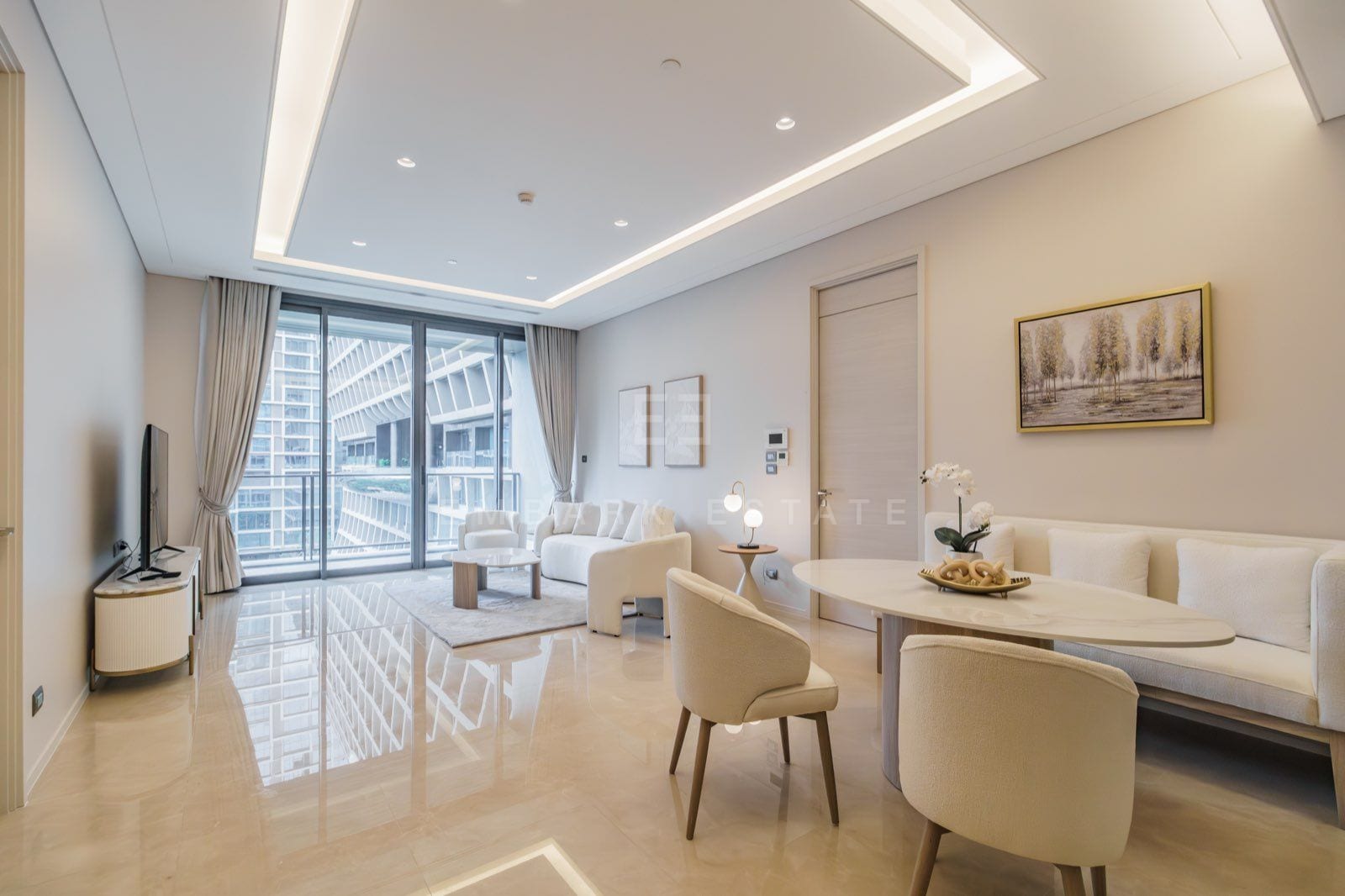 ห้องนั่งเล่นและห้องอาหารของยูนิตสองห้องนอนที่ The Residences at Sindhorn Kempinski Hotel Bangkok พร้อมโซฟาสีครีม โต๊ะอาหาร และวิวเมือง