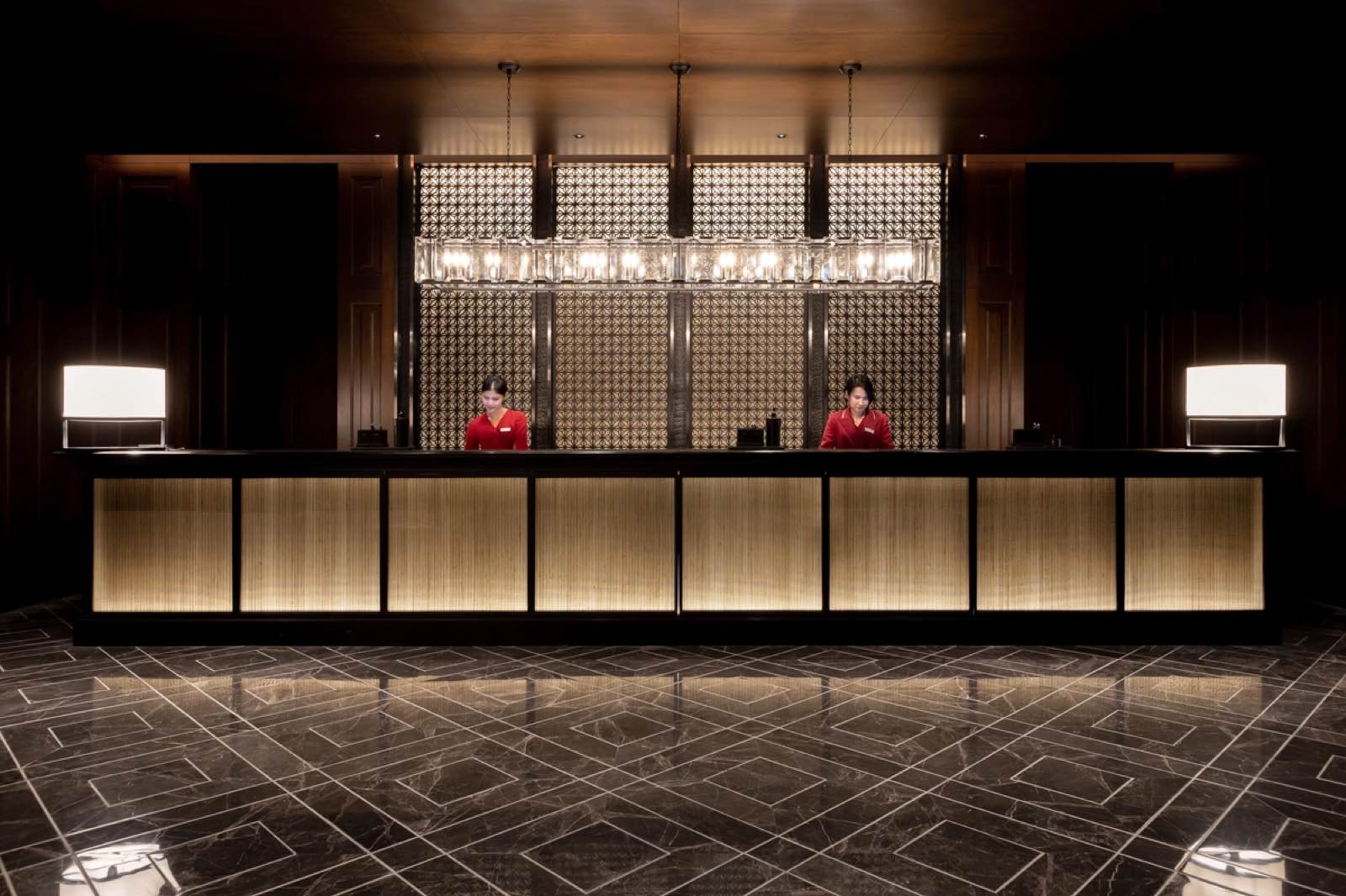 Grand reception desk with a bronze screen backdrop at The Residences at Sindhorn Kempinski Hotel Bangkok