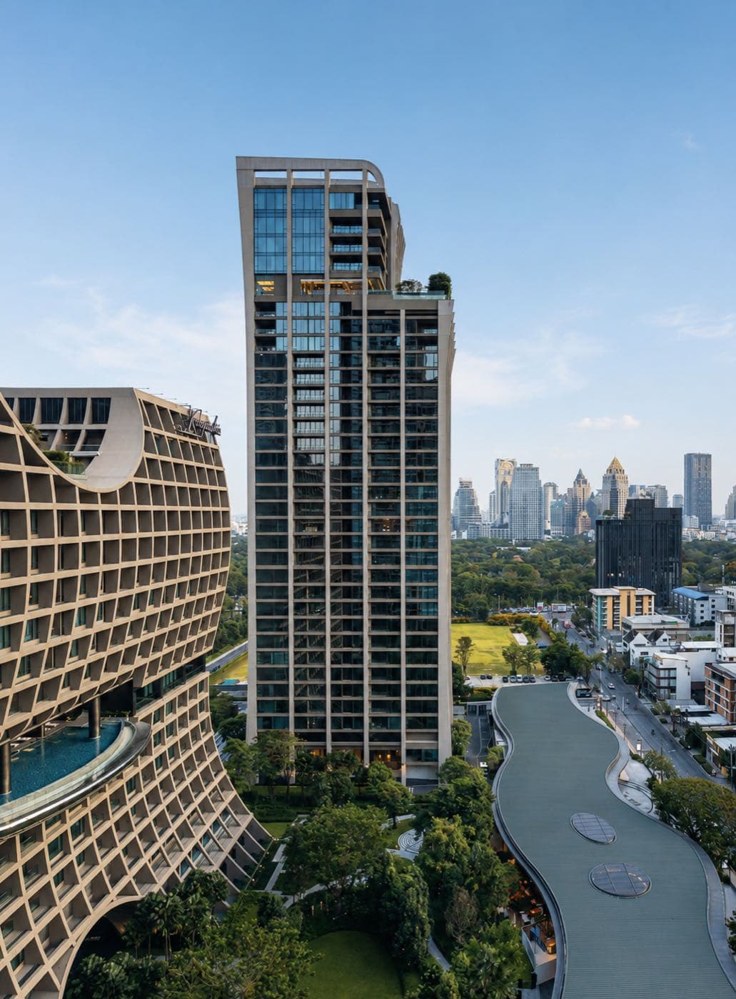 The Residences at Sindhorn Kempinski 的住宅大樓,毗鄰弧形的 Sindhorn Kempinski 酒店與曼谷市中心的 Lumphini Park