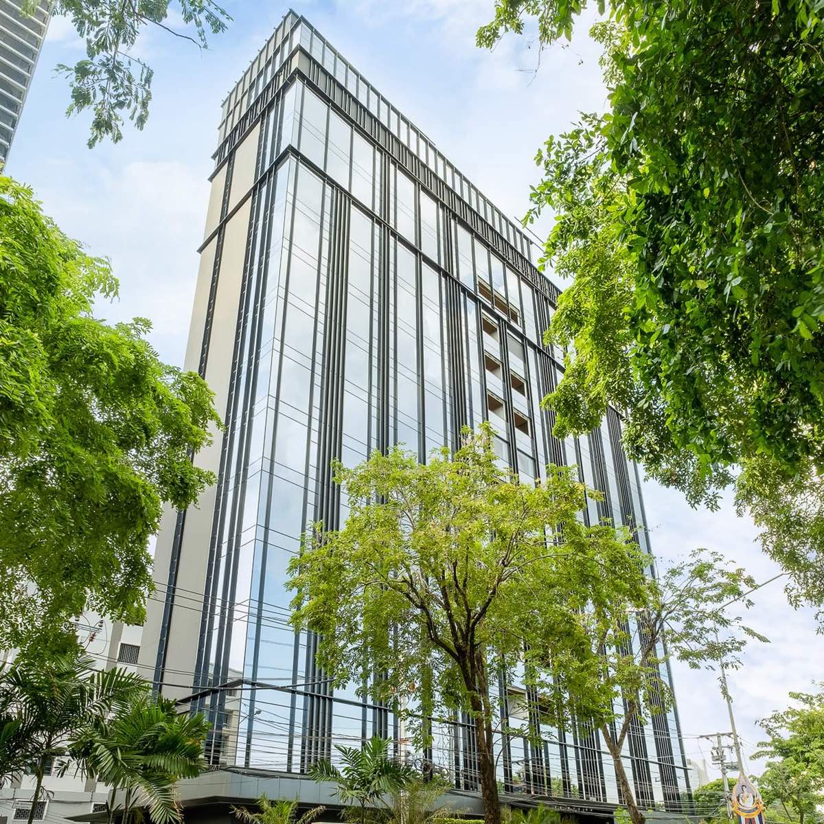 Sindhorn Lumpini glass tower among mature trees beside Lumphini Park in central Bangkok, by Siam Sindhorn