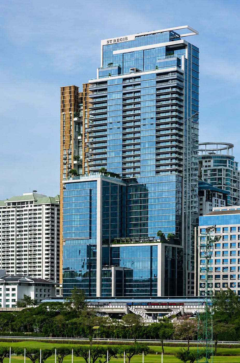 The Residences at The St. Regis Bangkok tower on Ratchadamri Road, seen across the green of the Royal Bangkok Sports Club in central Bangkok