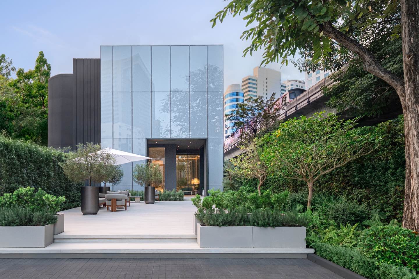 Photograph of the STILL Sukhumvit 20 sales gallery on Sukhumvit Soi 20, a glass pavilion set in its own garden