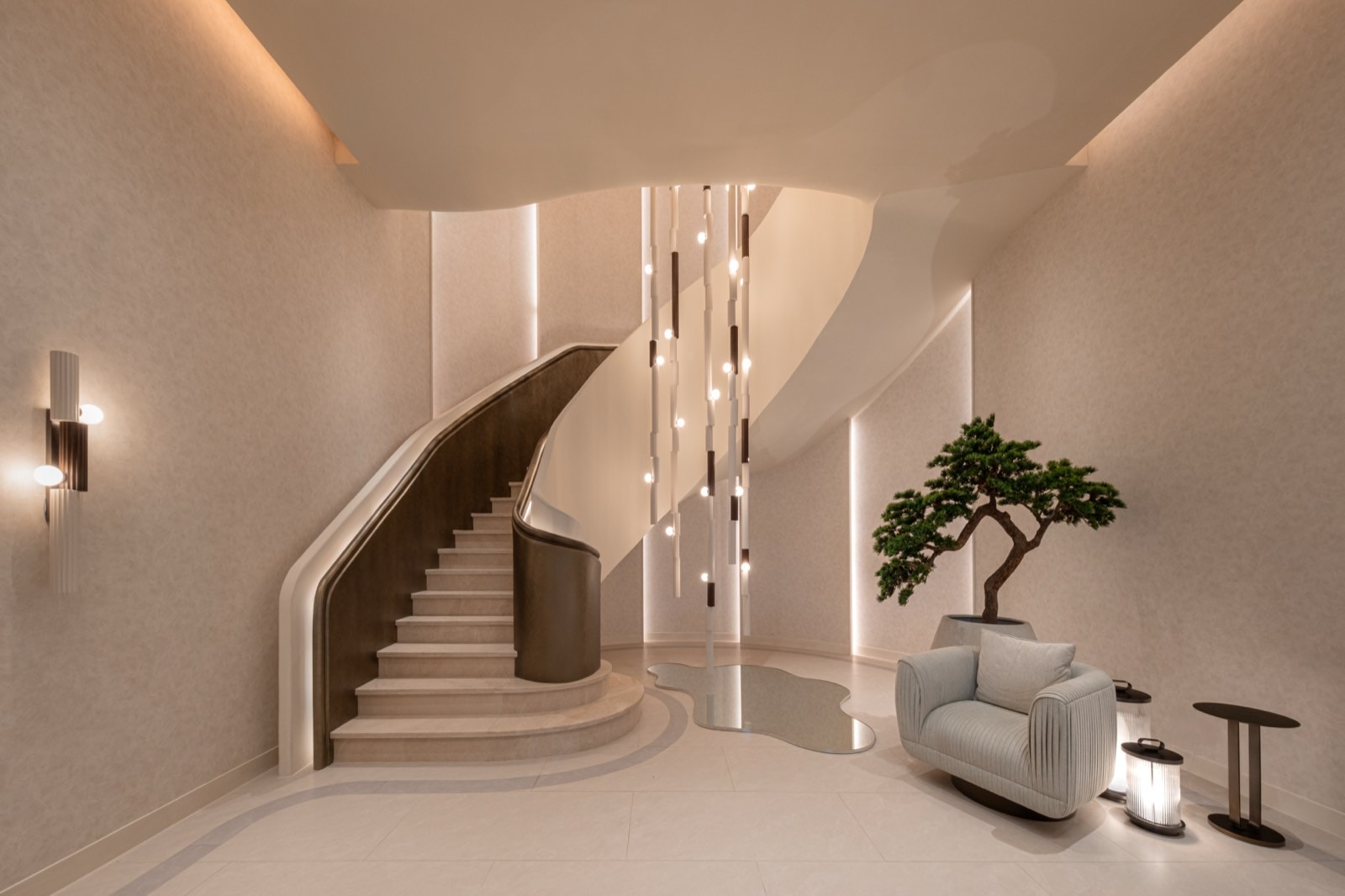 Photograph of the sculptural spiral staircase inside the STILL Sukhumvit 20 sales gallery, with its cascading pendant chandelier