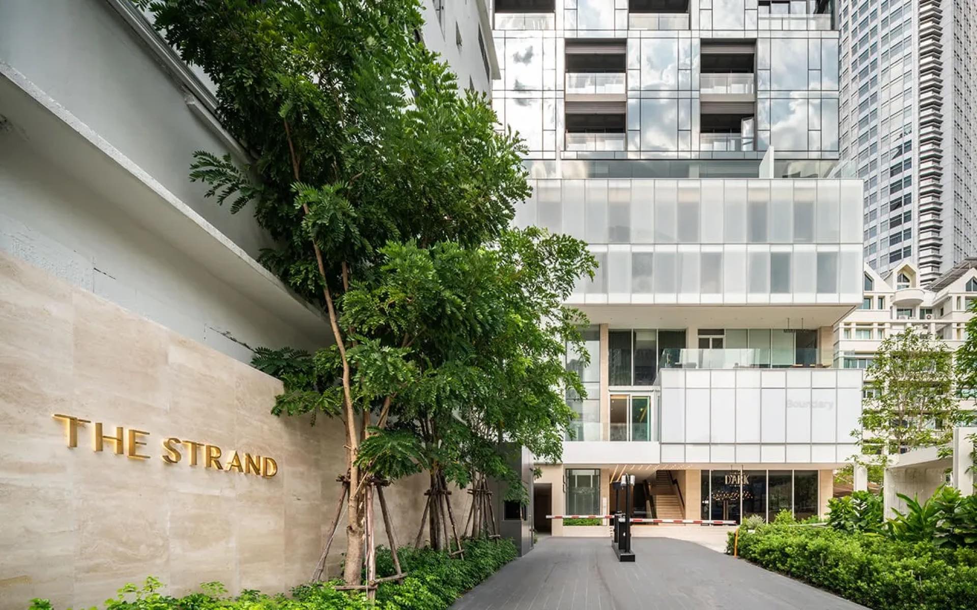 The Strand Thonglor: ground-level signed entrance facade and landscaped approach