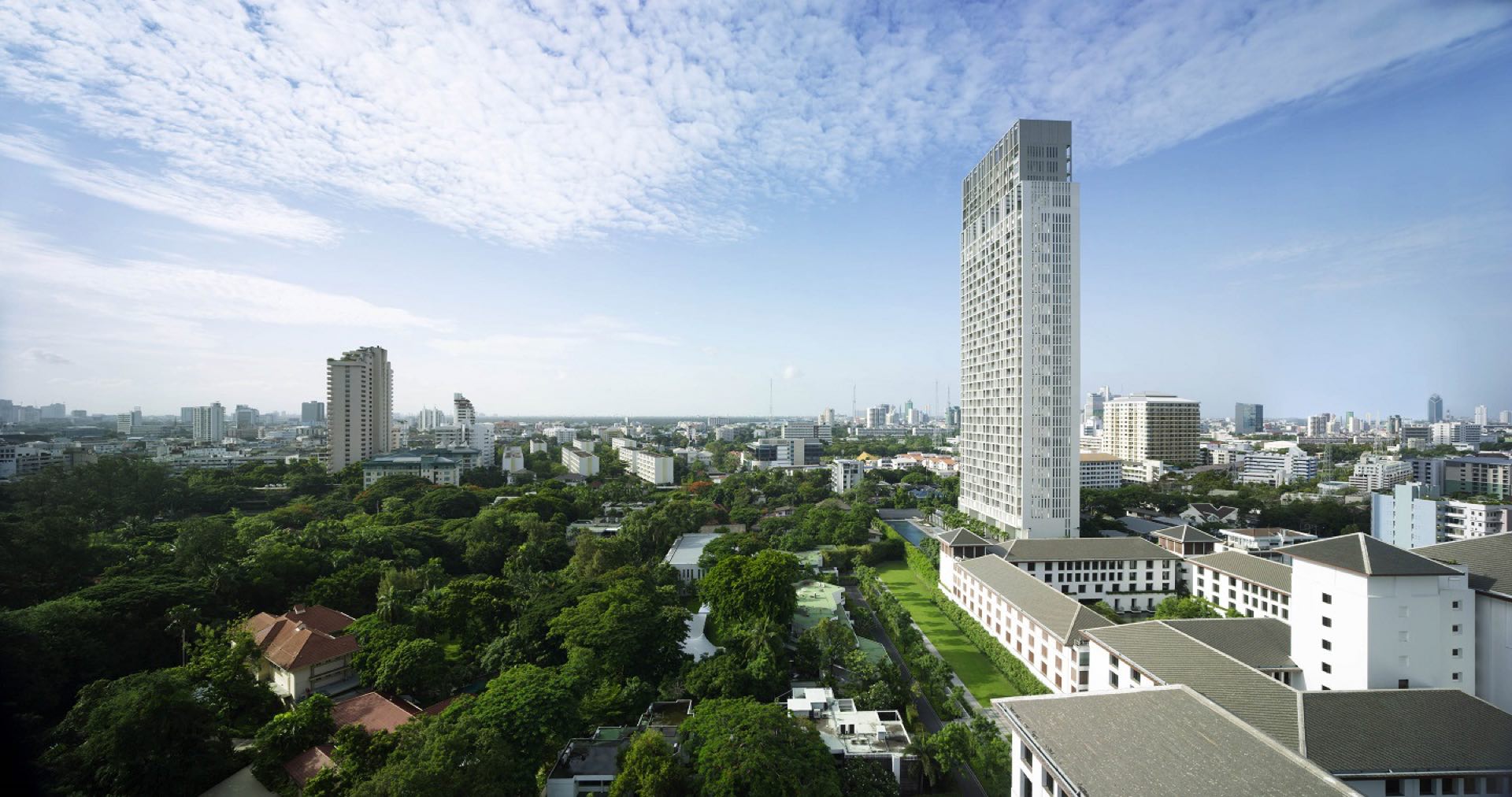 The Sukhothai Residences: Aerial view of The Sukhothai Residences white tower above the green grounds of The Sukhothai Bangkok and the Sathorn skyline