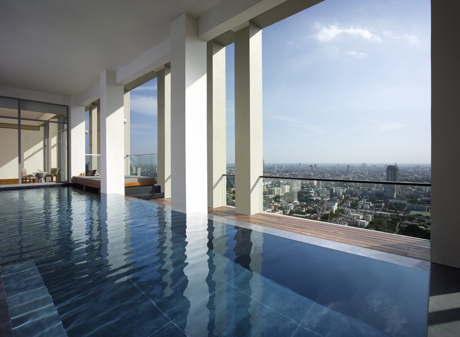 The Sukhothai Residences: Indoor-edge sky pool with columns framing a panoramic view over the Bangkok cityscape