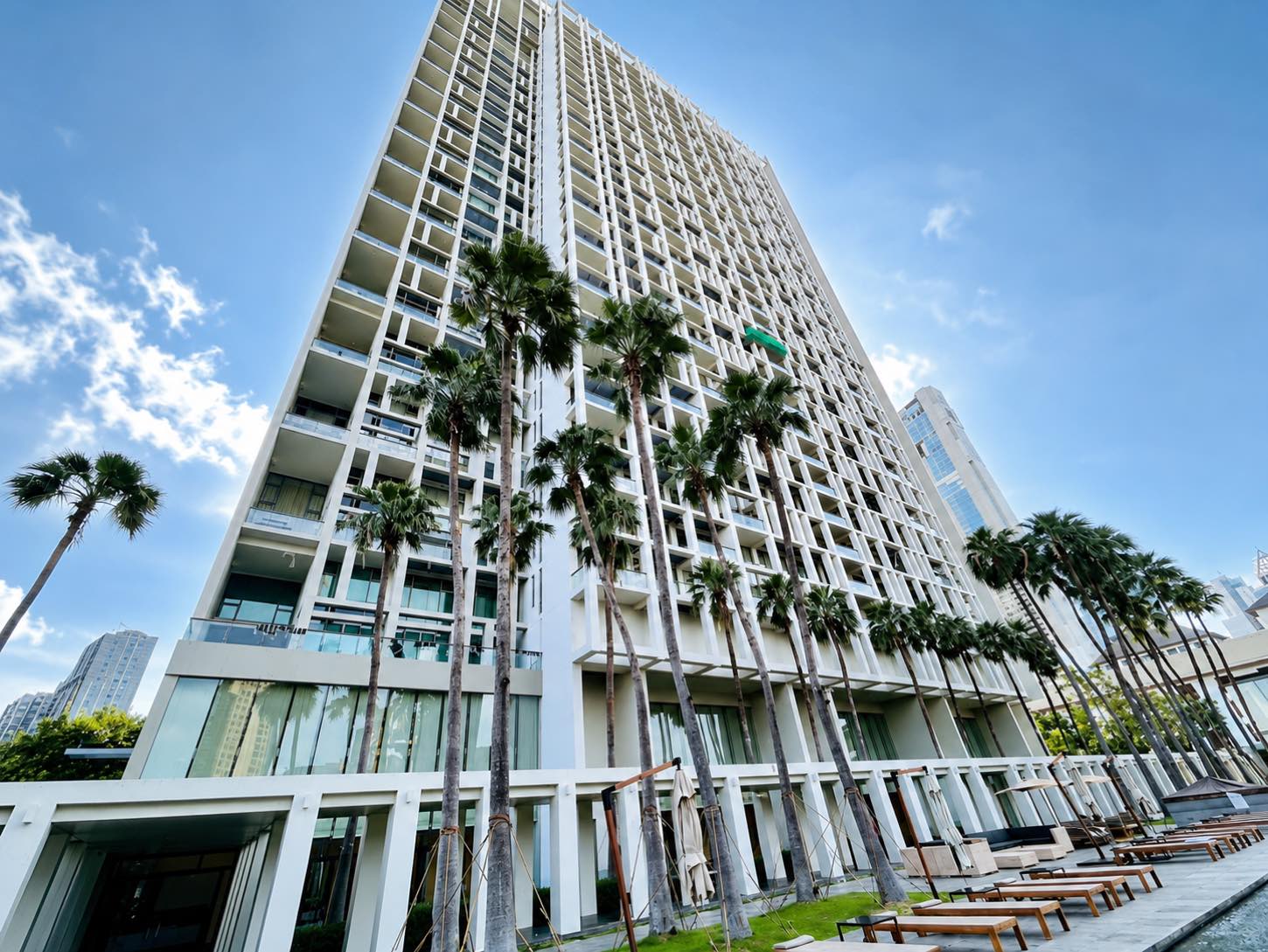 The Sukhothai Residences: the white residential tower rising behind the palm-lined pool terrace of The Sukhothai Bangkok on Sathorn in central Bangkok