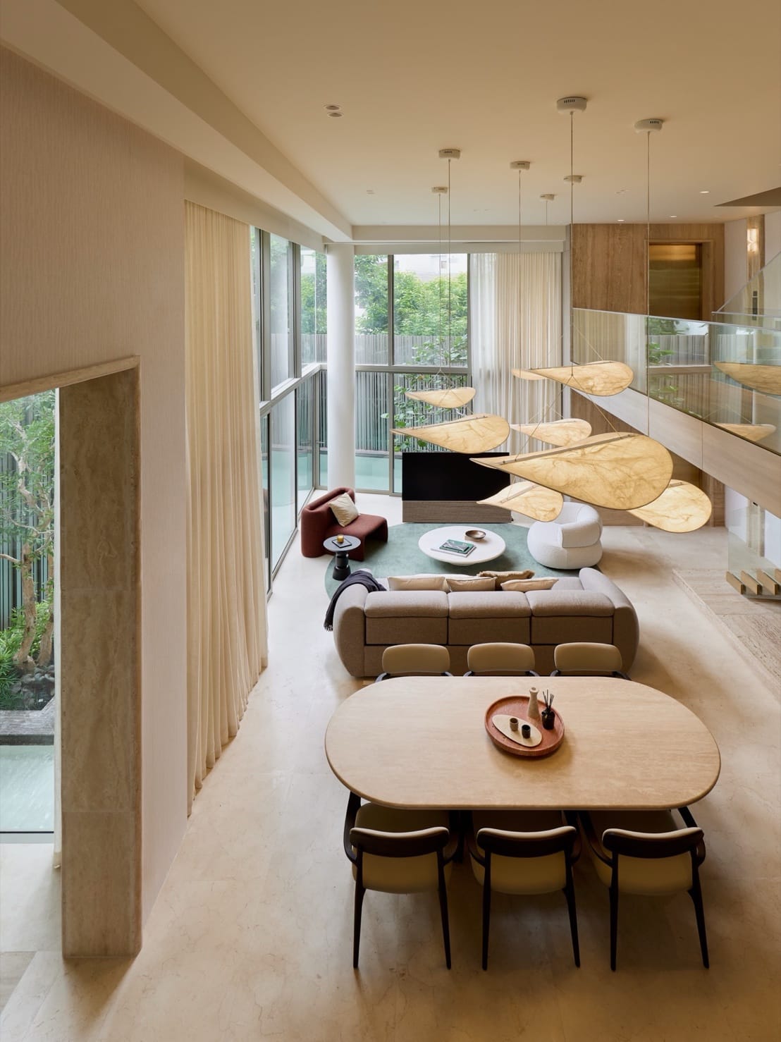 The double-height living and dining room of the Type A show house at The Residenti Ekkamai, Bangkok, with a garden on two sides