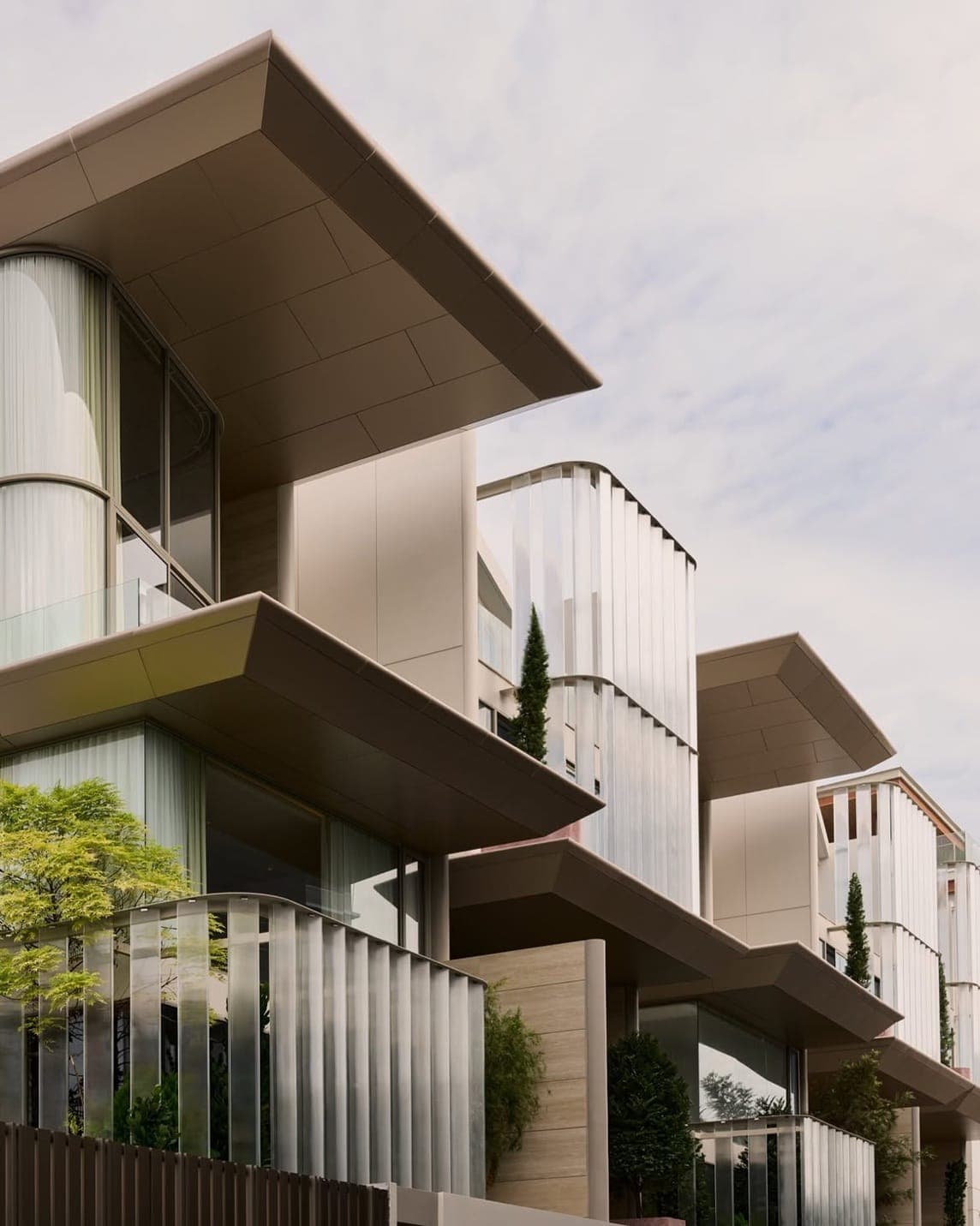The row of houses at The Residenti Ekkamai on Soi Sukhumvit 65, Bangkok, with deep overhanging floors and curved fluted glass screens