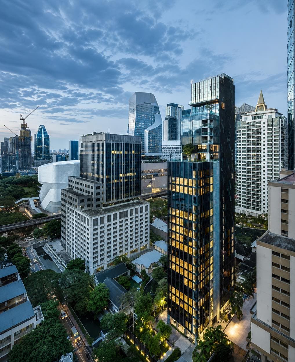Tonson One: the slender freehold tower with its illuminated glass facade in the evening above the Ploenchit and Langsuan skyline in central Bangkok, by Asset Five Group
