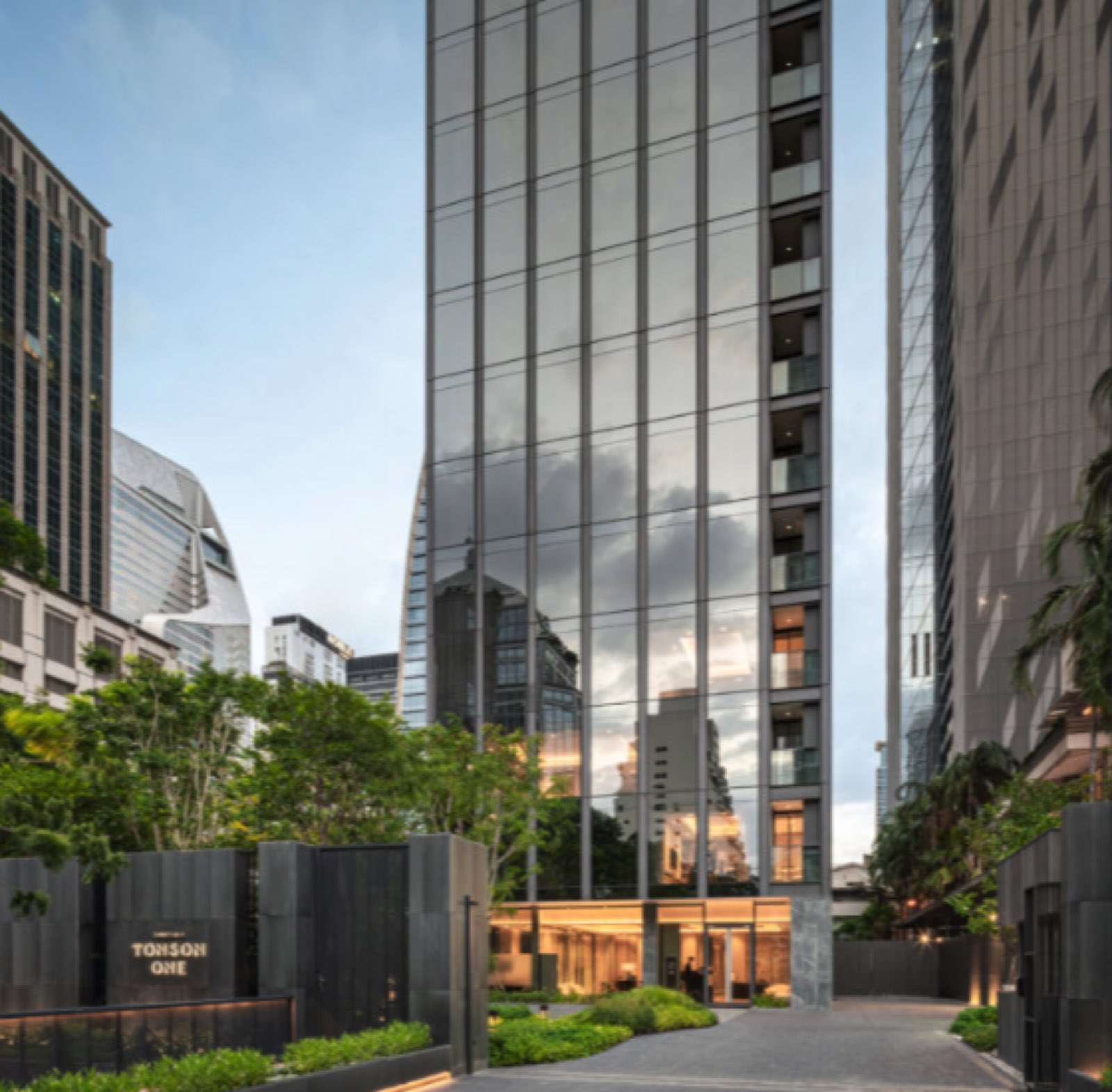 The glass facade and landscaped entrance of Tonson One on Tonson Lane, central Bangkok, with the Tonson One signage