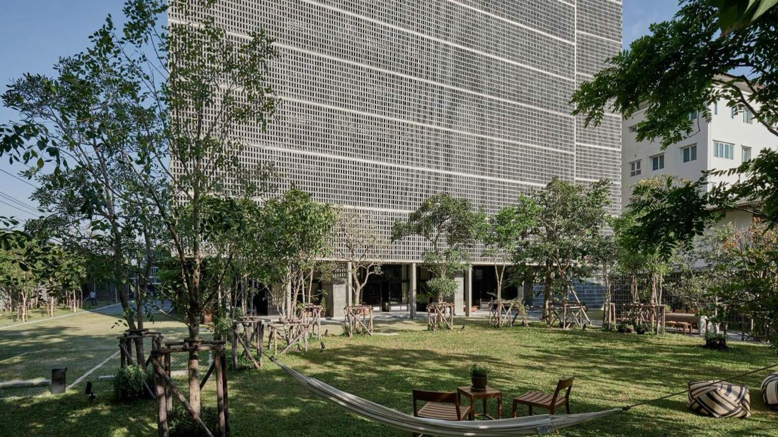 Windshell Naradhiwas ground-floor garden entrance beneath the perforated concrete facade