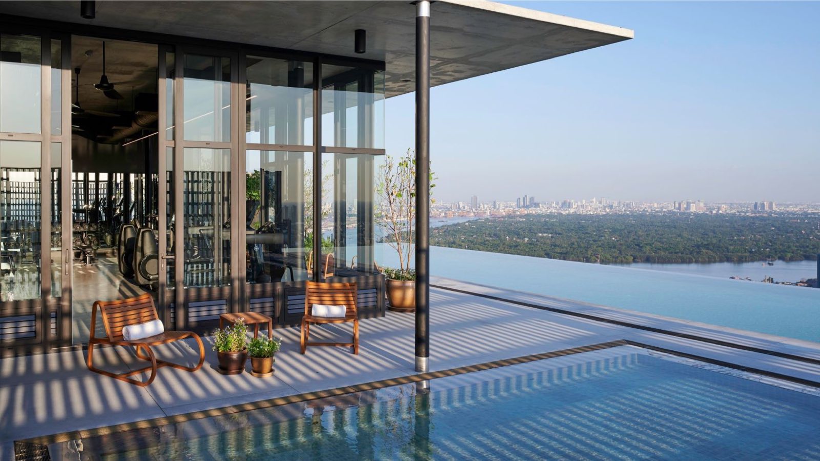 Windshell Naradhiwas rooftop infinity pool and gym with a wide Bangkok skyline view
