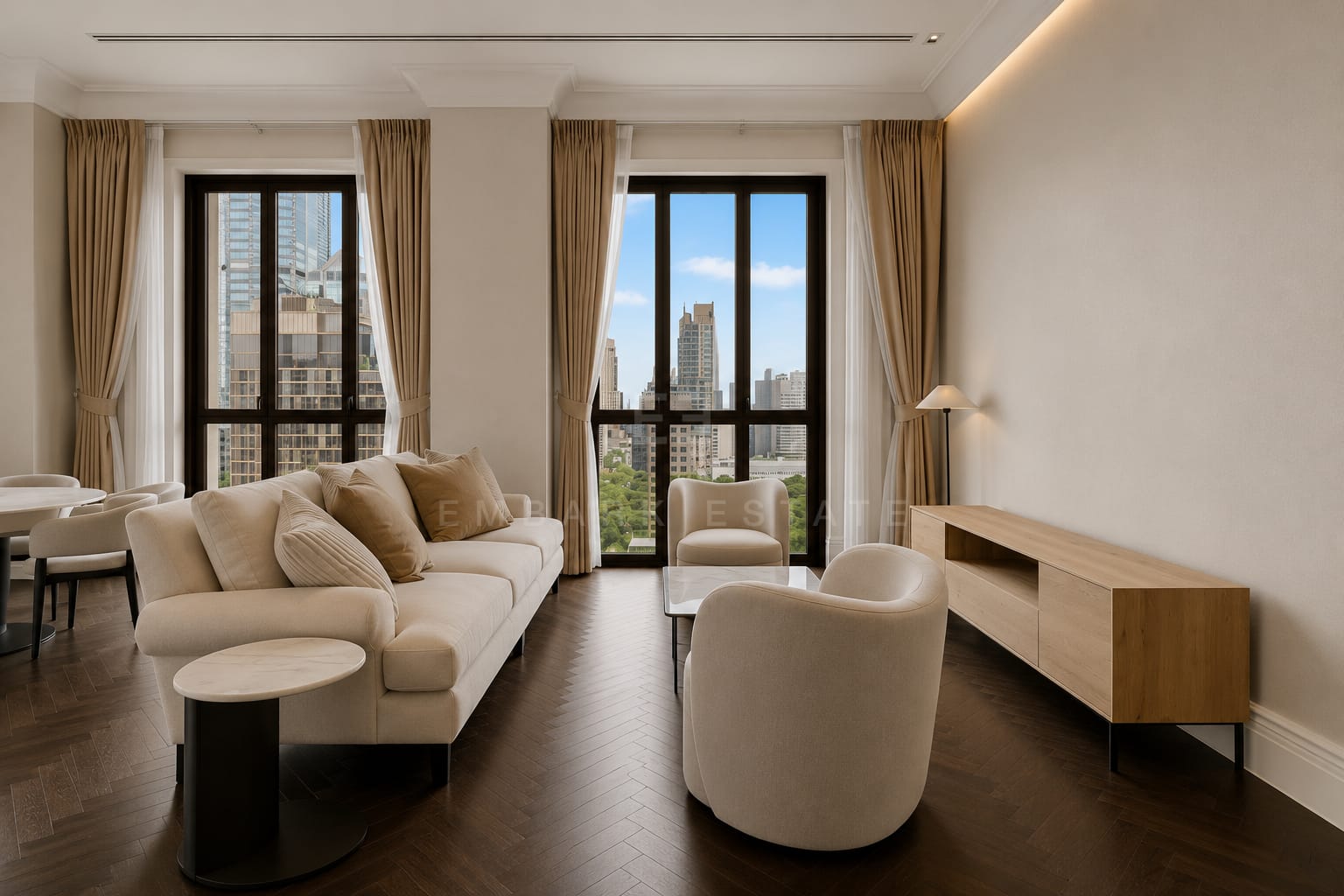 The living room at 98 Wireless, a cream sofa and armchair beside an oak console with the city through the French windows