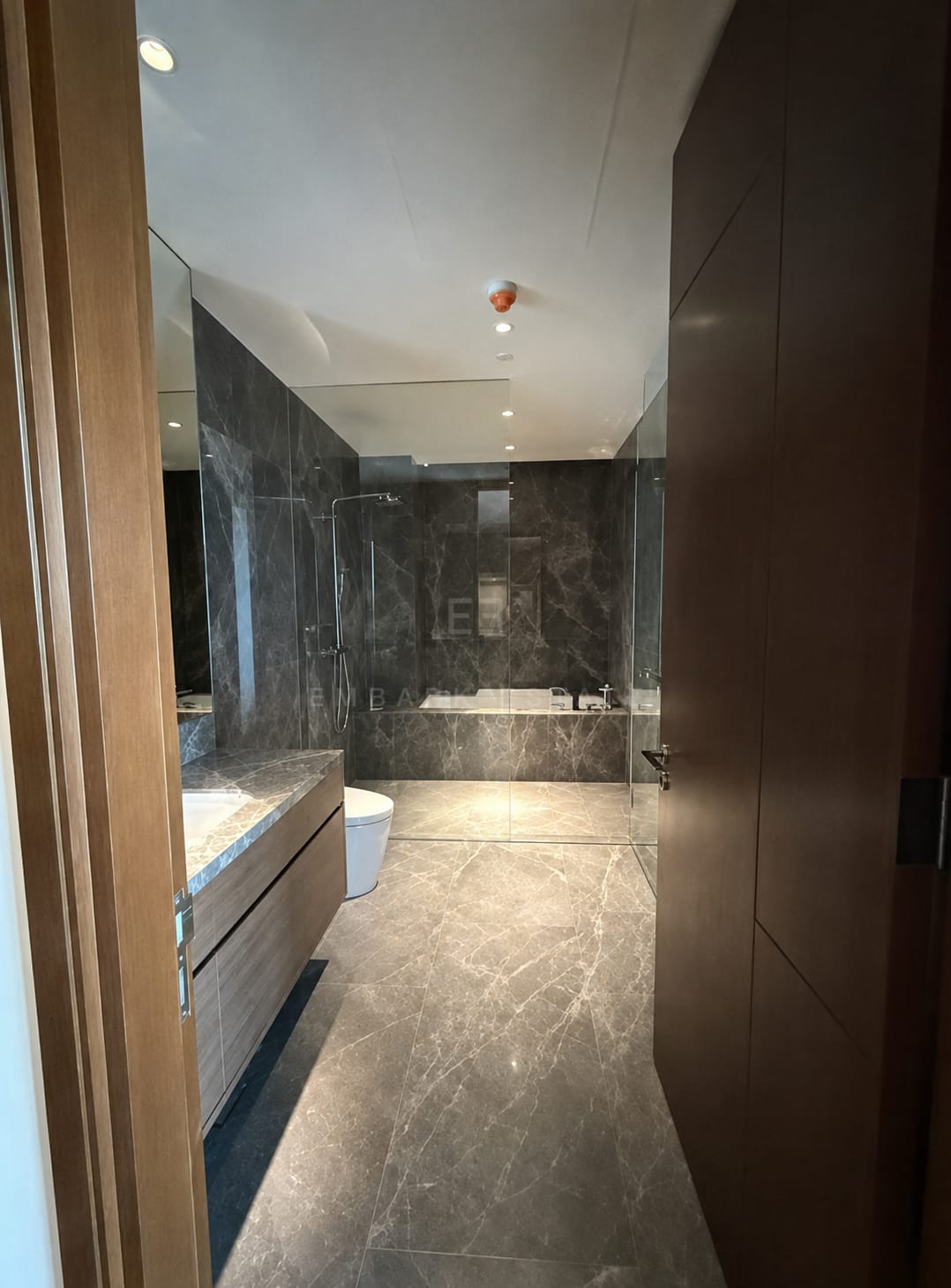 The main bathroom at Dusit Parkside, Dusit Central Park, a freestanding tub and a glazed shower in dark grey marble