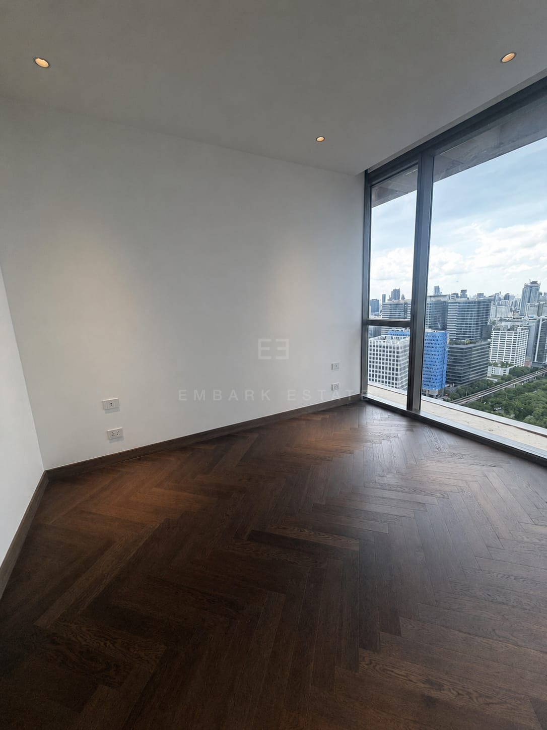 Master bedroom at Dusit Residences, Dusit Central Park, Bangkok, with corner glazing over the park edge