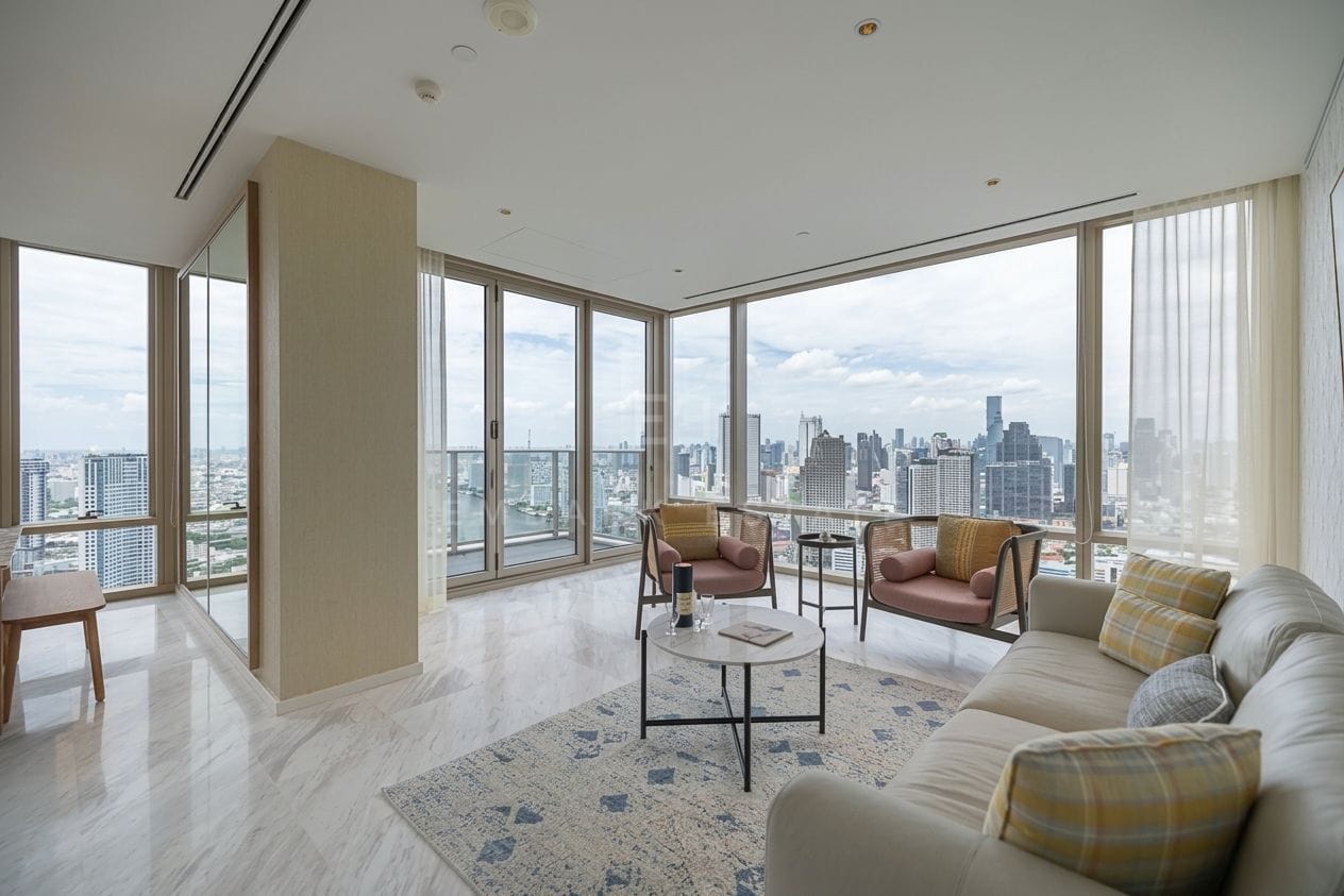 Four Seasons Private Residences Bangkok — living room with sofa and armchairs at the corner windows