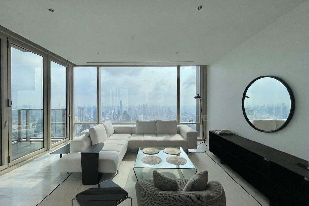 Four Seasons Private Residences Bangkok — living room with sofas, round mirror and balcony skyline view