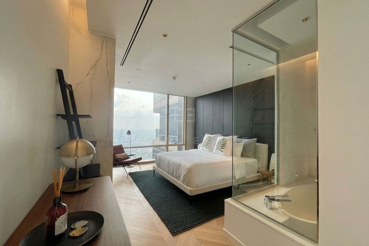 Four Seasons Private Residences Bangkok — bedroom and bathtub seen through the glass partition