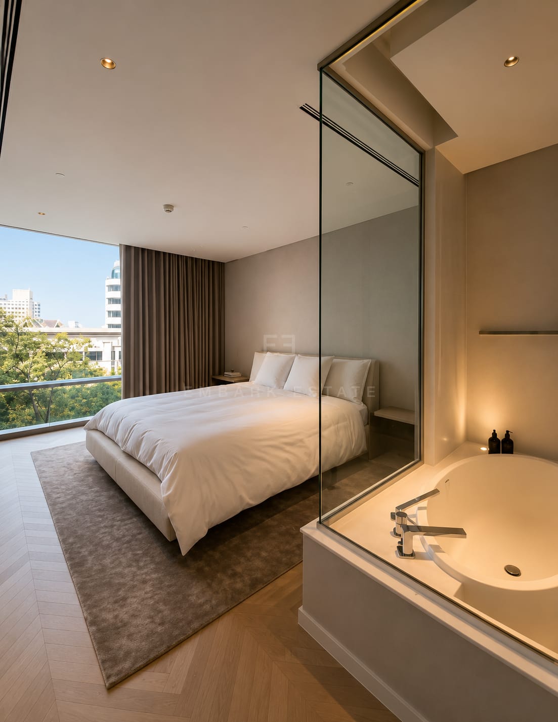 The bedroom at Four Seasons Private Residences, the bathtub set behind a glass partition beside the bed on a herringbone timber floor