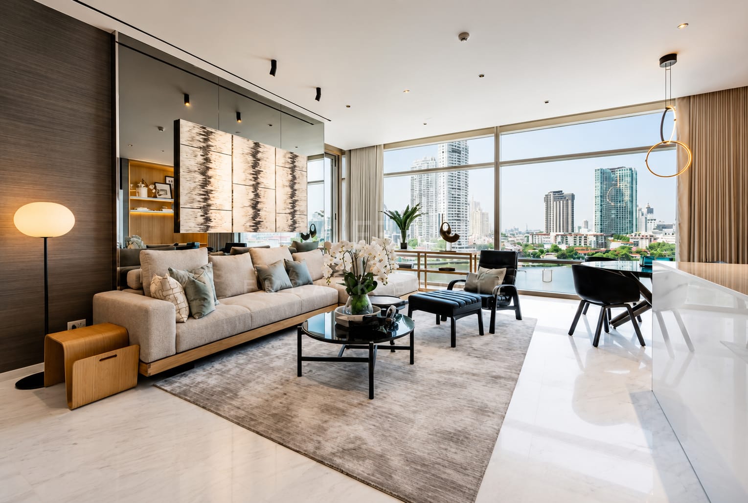 The living room of the 137 square metre residence at Four Seasons Private Residences, a sofa and black tables on a rug with sliding glass onto the river balcony