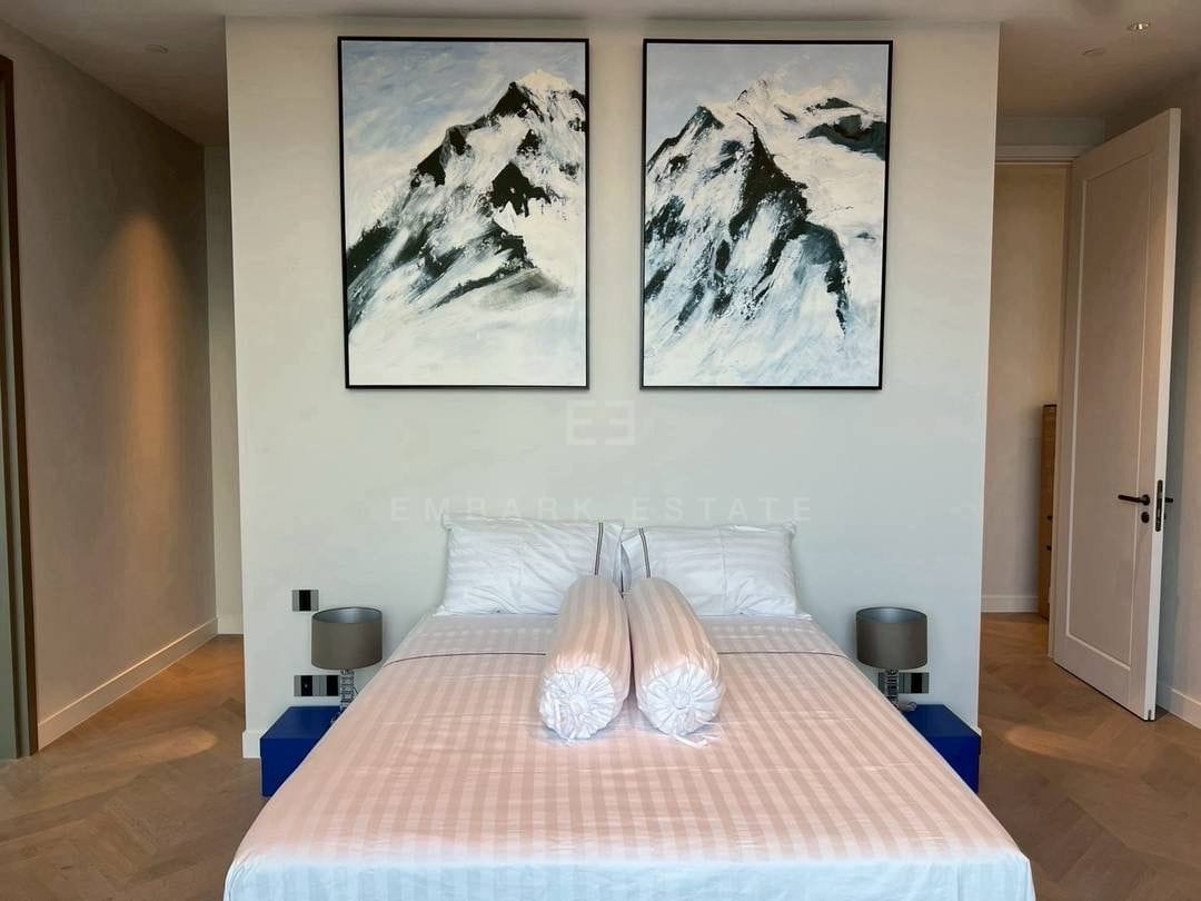 A bedroom at ONE89 Wireless, a pair of framed mountain studies above the bed with a lamp to either side on timber floors