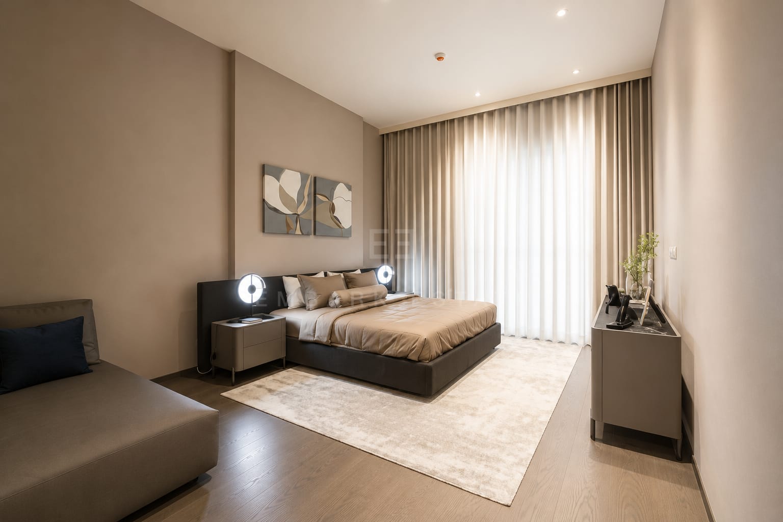 The main bedroom at Scope Langsuan, a black upholstered headboard with round lamps and a daybed alongside