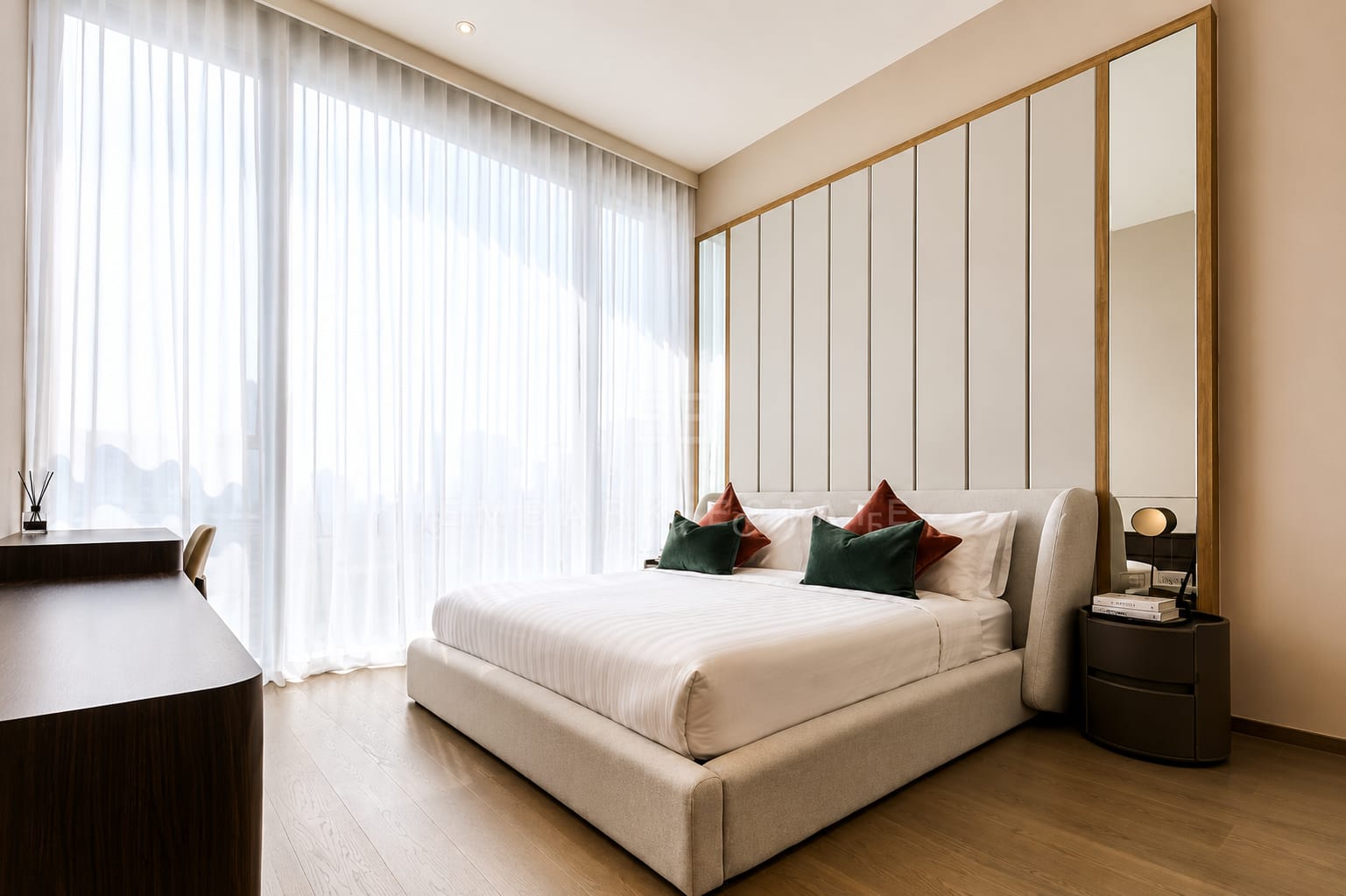 The bedroom at Scope Langsuan, a fabric-panelled headboard wall with a writing desk under the sheer curtains