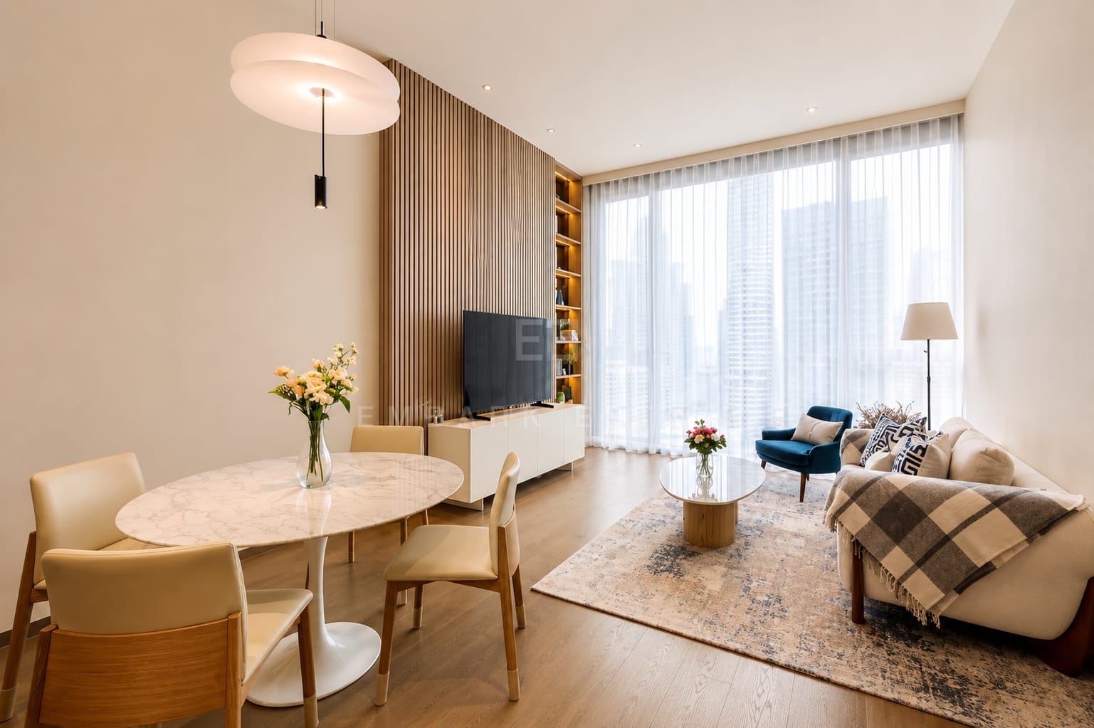 The dining and living room at Scope Langsuan, the round table under a saucer pendant with the sofa and armchair at the glazing