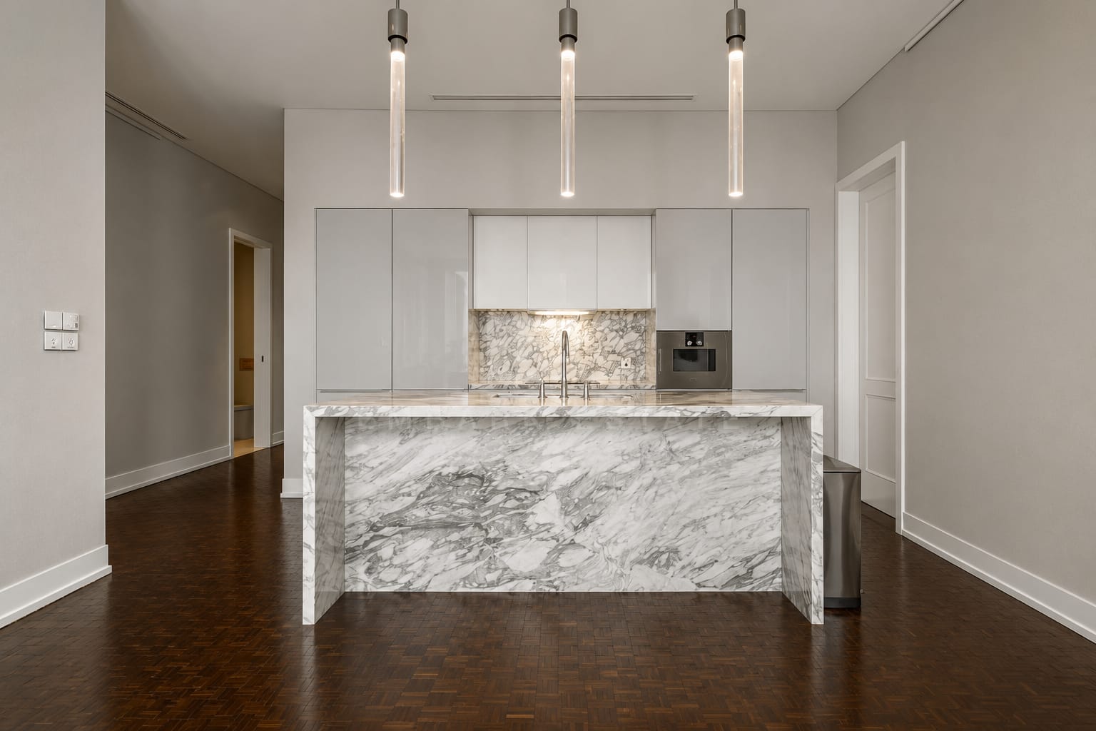 The kitchen island at The Ritz-Carlton Residences Bangkok, marble carried down both ends and up the splashback behind