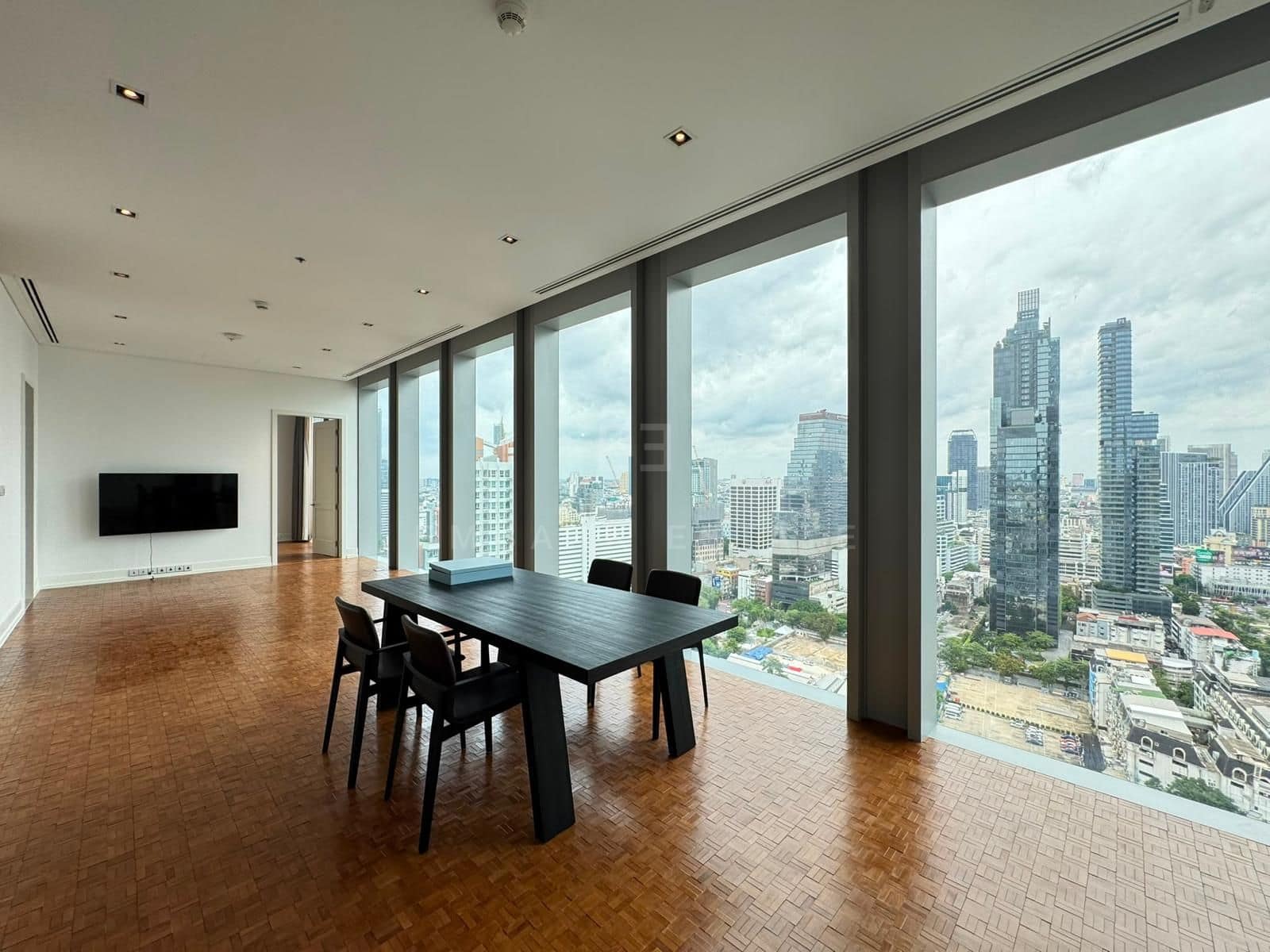 The living and dining room at The Ritz-Carlton Residences Bangkok, unfurnished, glazing running the full width above Sathorn and Silom