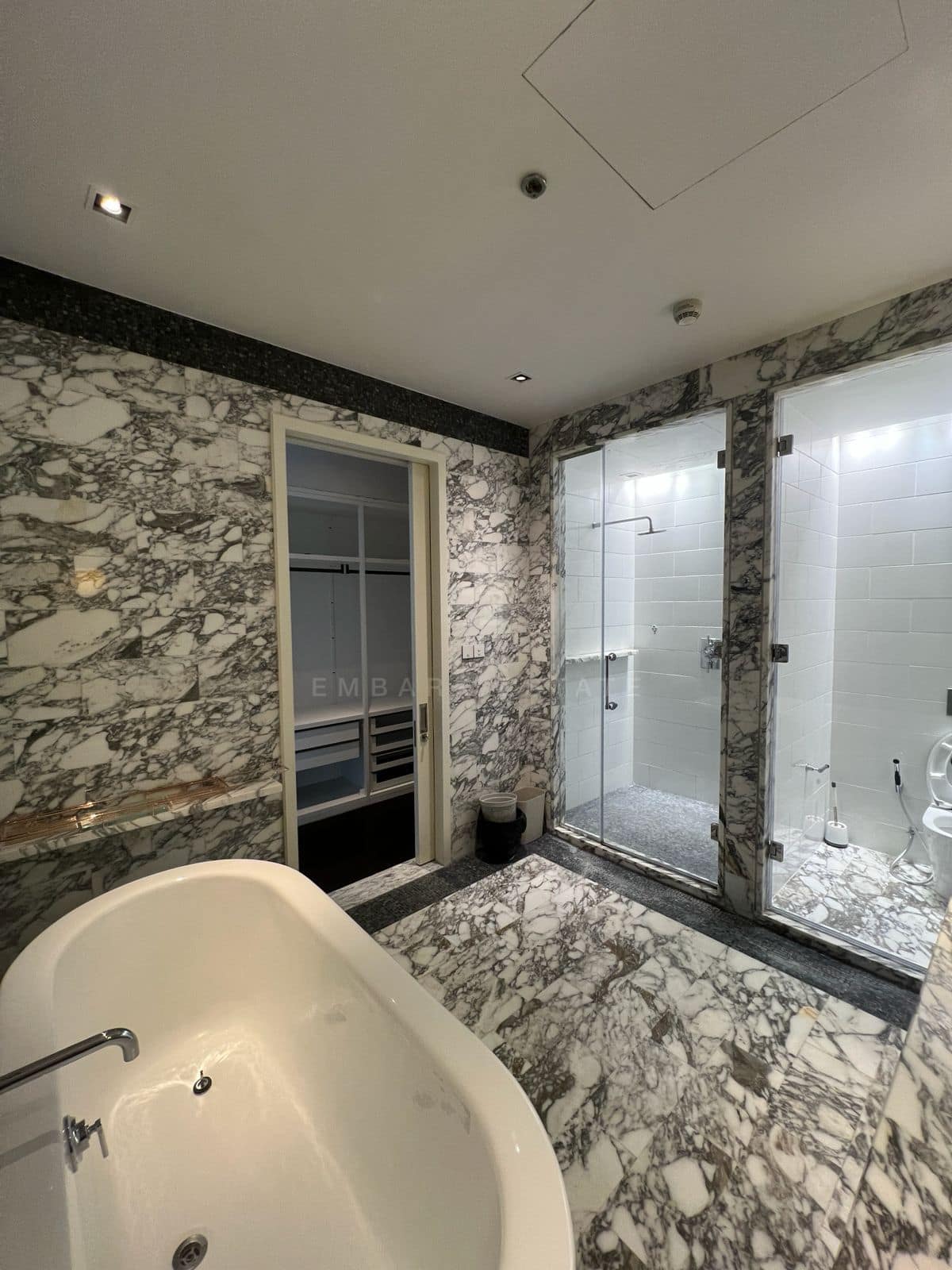 The master bathroom at The Ritz-Carlton Residences Bangkok on the 43rd floor, a freestanding tub against veined marble