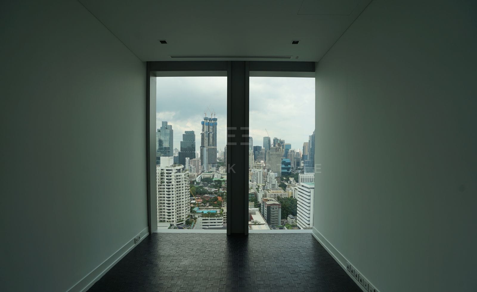 A room of the 27th-floor residence, dark timber-block floor and floor-to-ceiling glass over the city