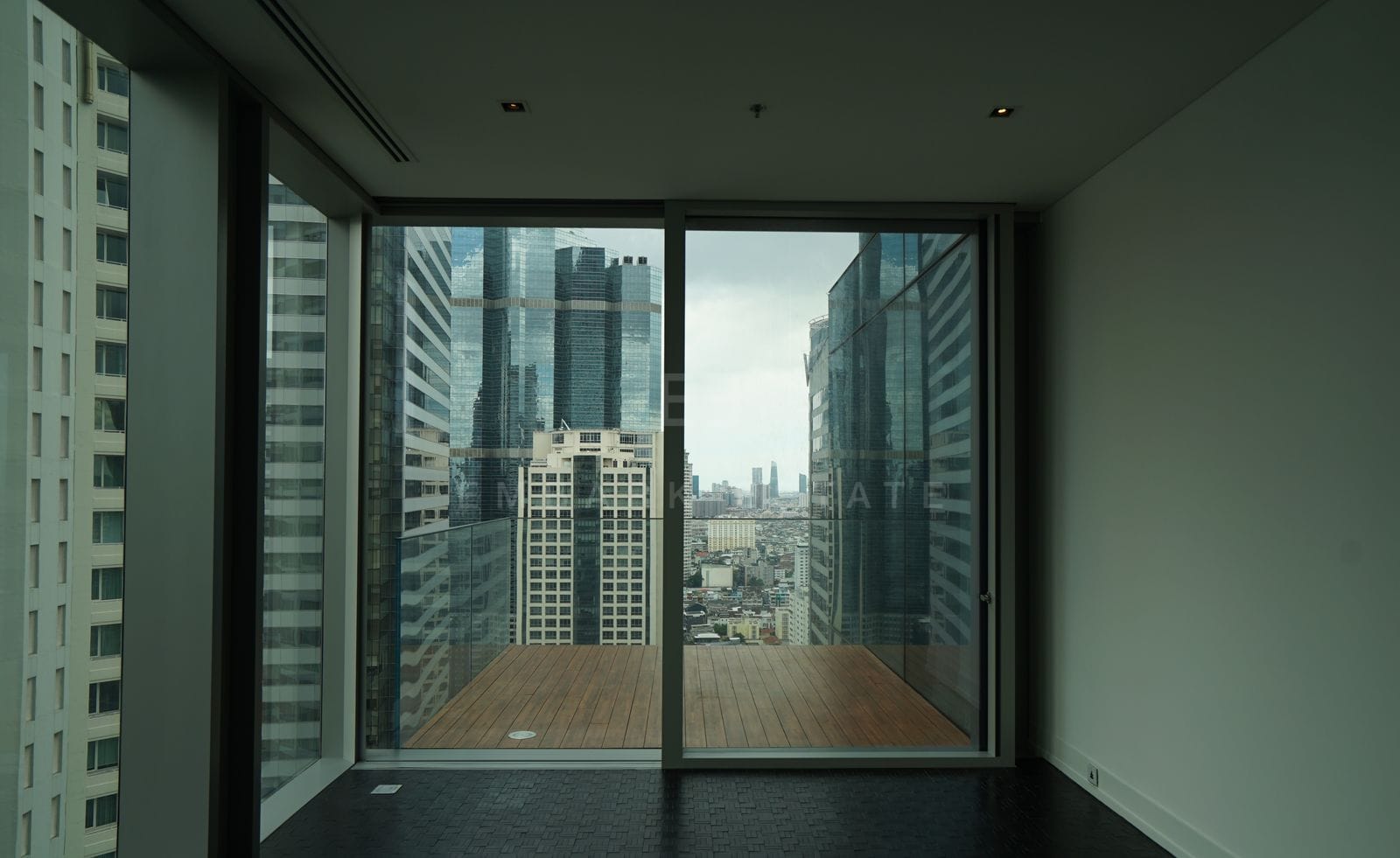 The corner living space of the residence, sliding glass opening to the timber-decked terrace