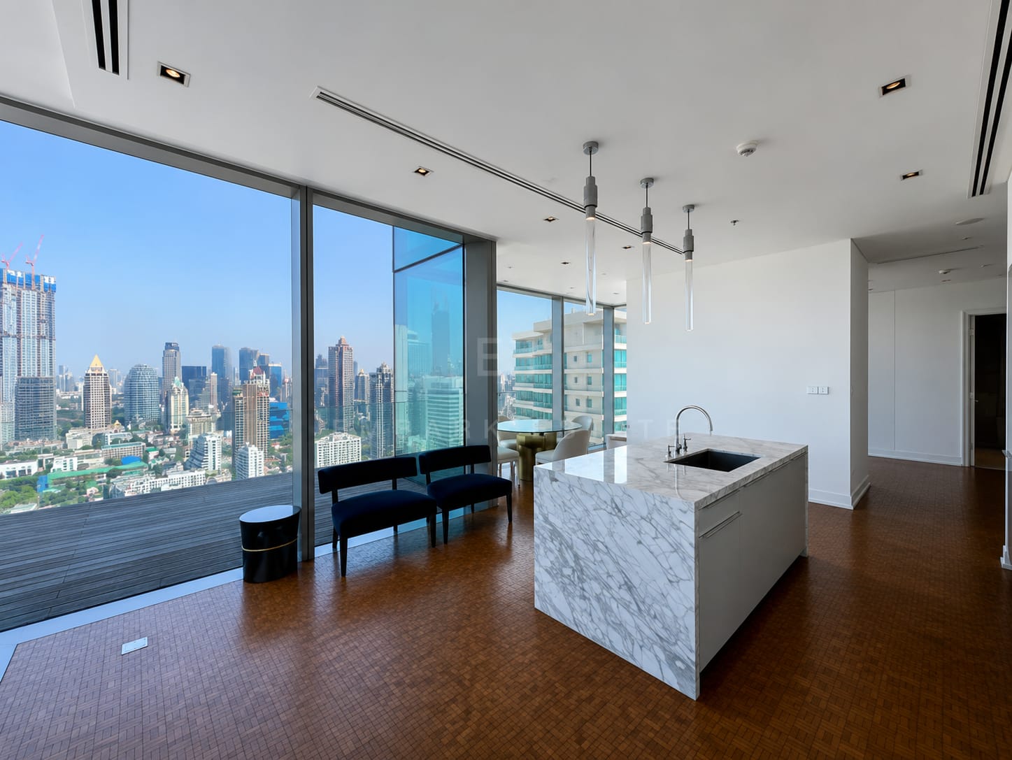 The Ritz-Carlton Residences Bangkok — living room with marble kitchen island opening to the 28 sq.m terrace