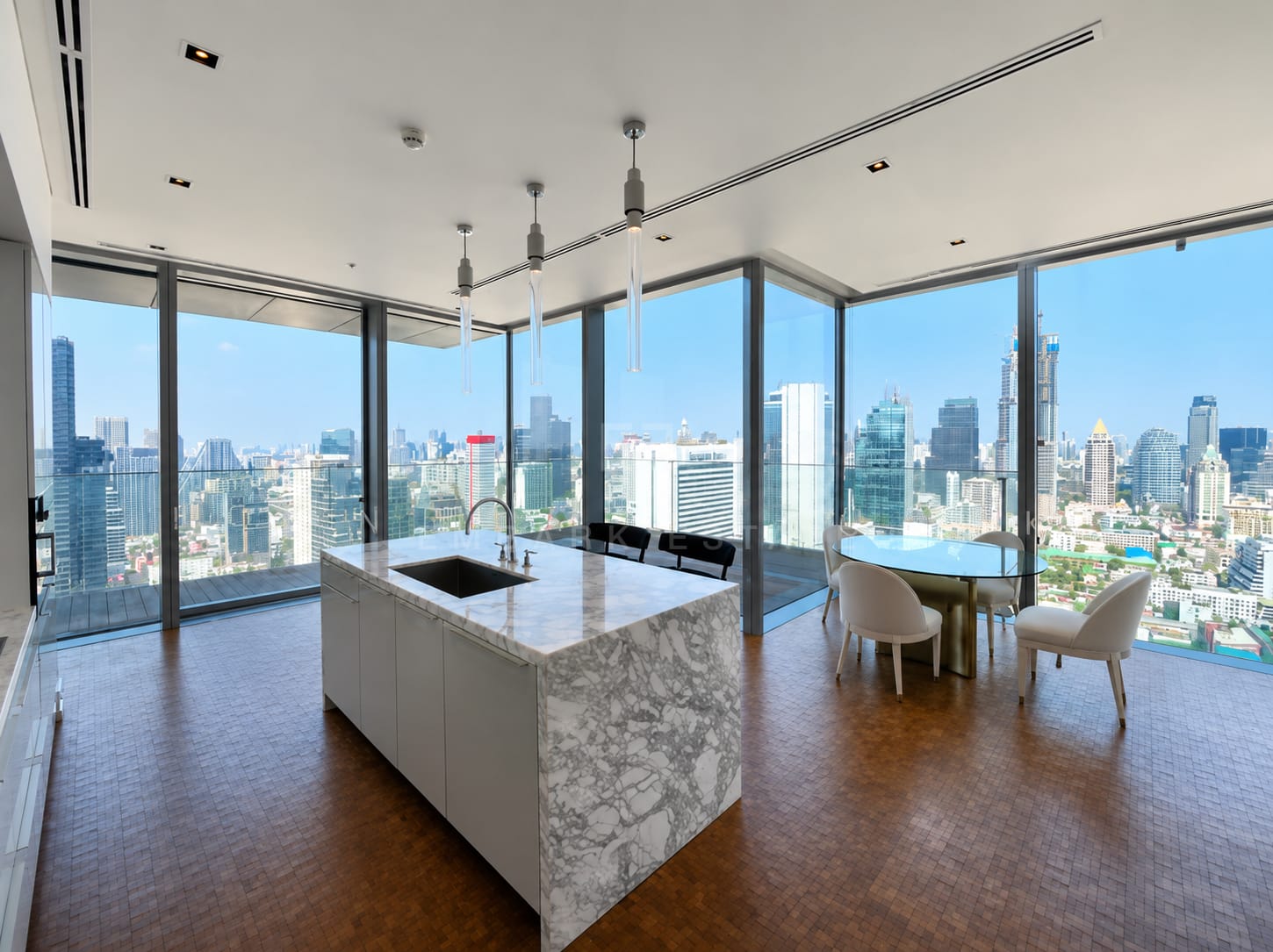 The Ritz-Carlton Residences Bangkok — marble kitchen island and dining corner against the skyline windows